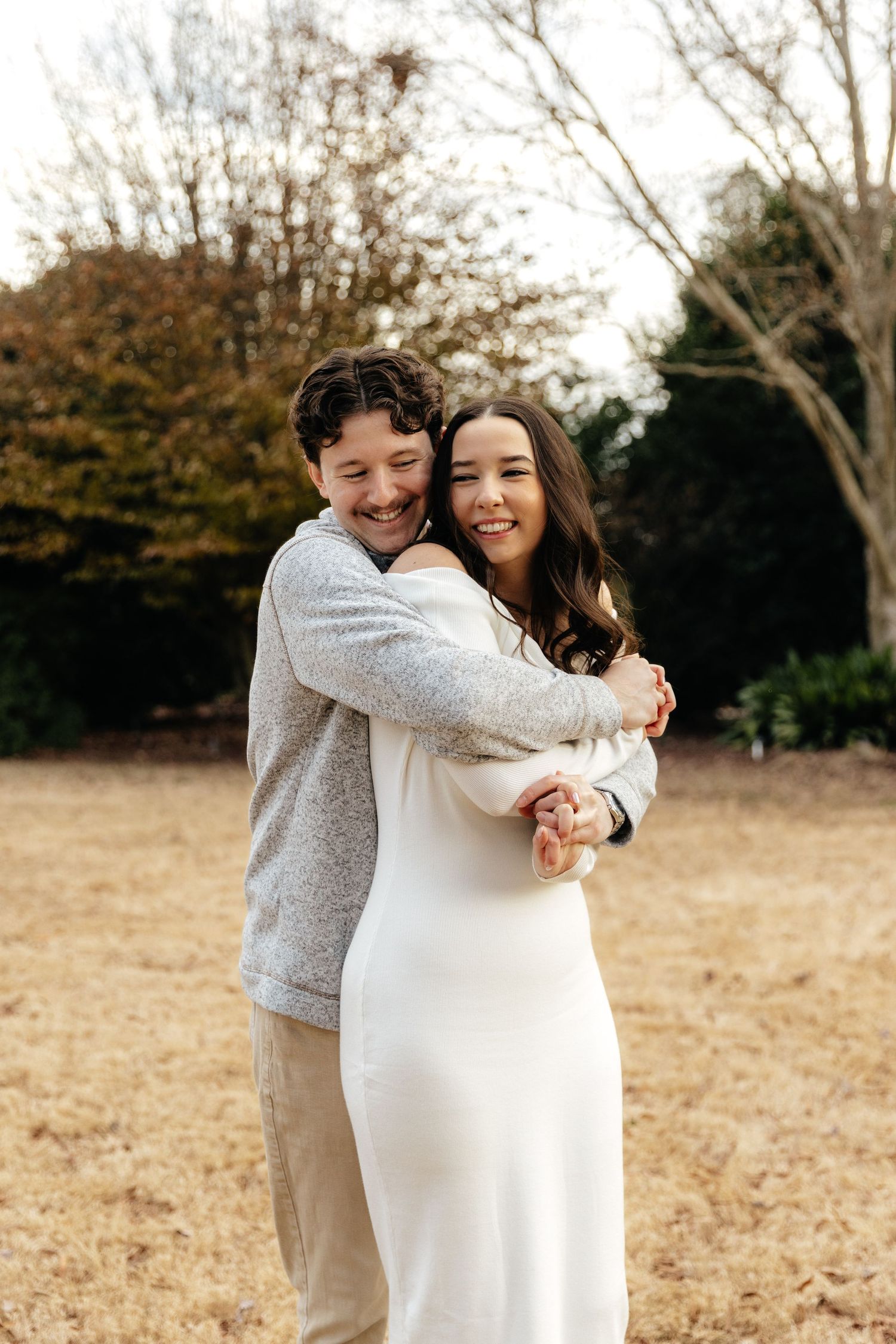 Sweet embrace captured during engagement photoshoot in autumn field.