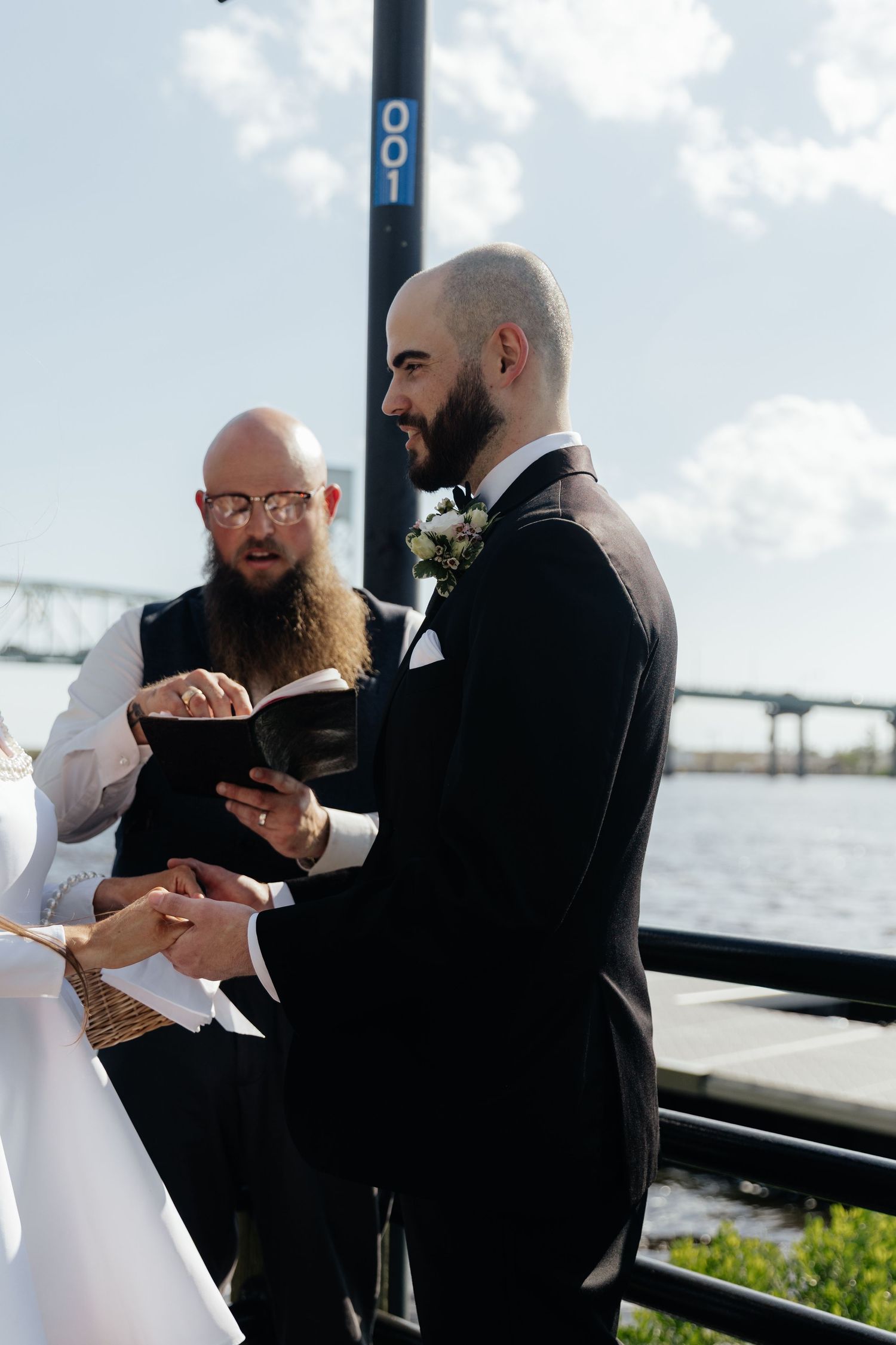 Intimate wedding ceremony taking place on a waterfront deck.