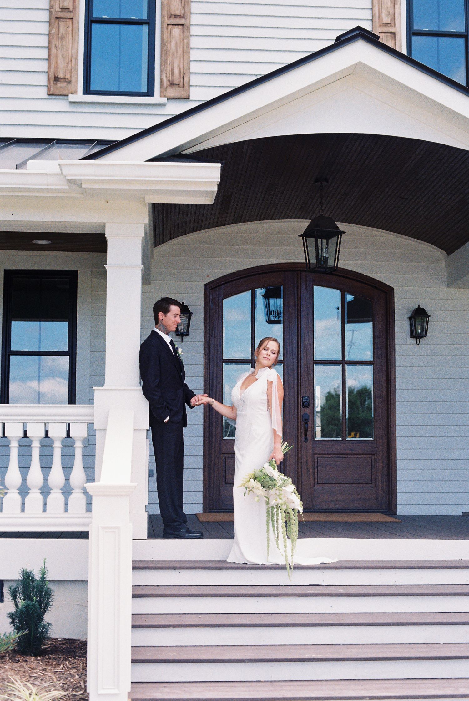 Classic white house with colonial architecture serving as wedding venue backdrop.