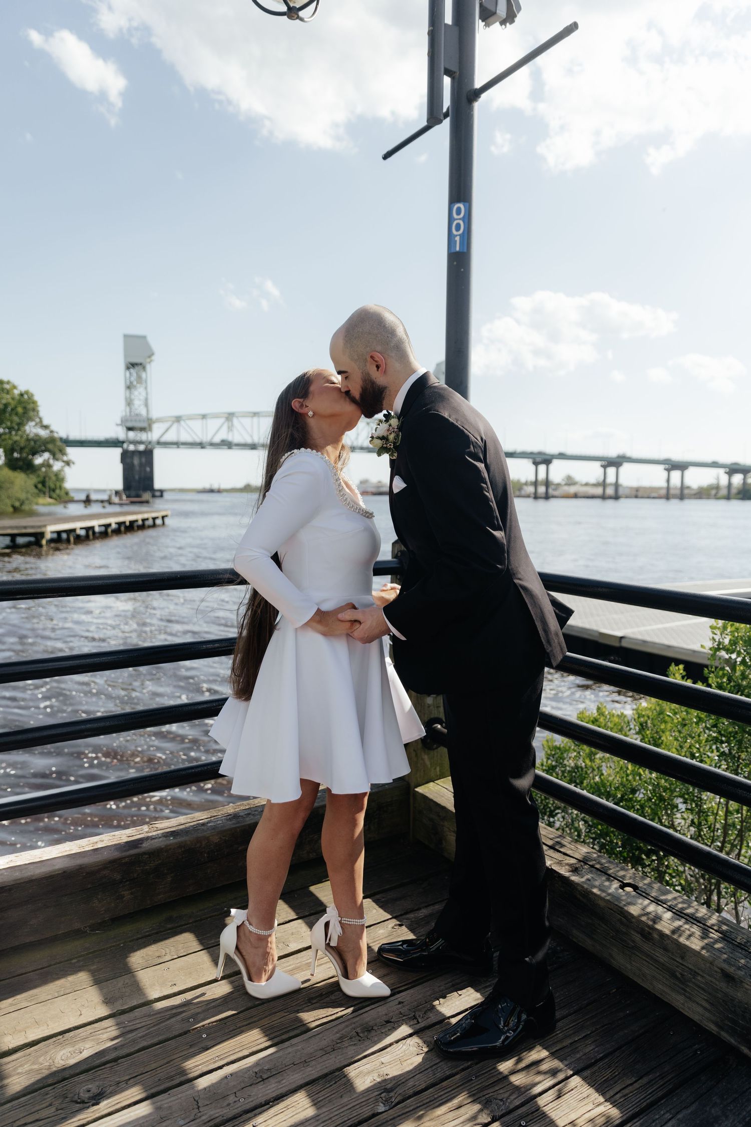 Couple sharing intimate moment during waterfront wedding ceremony.