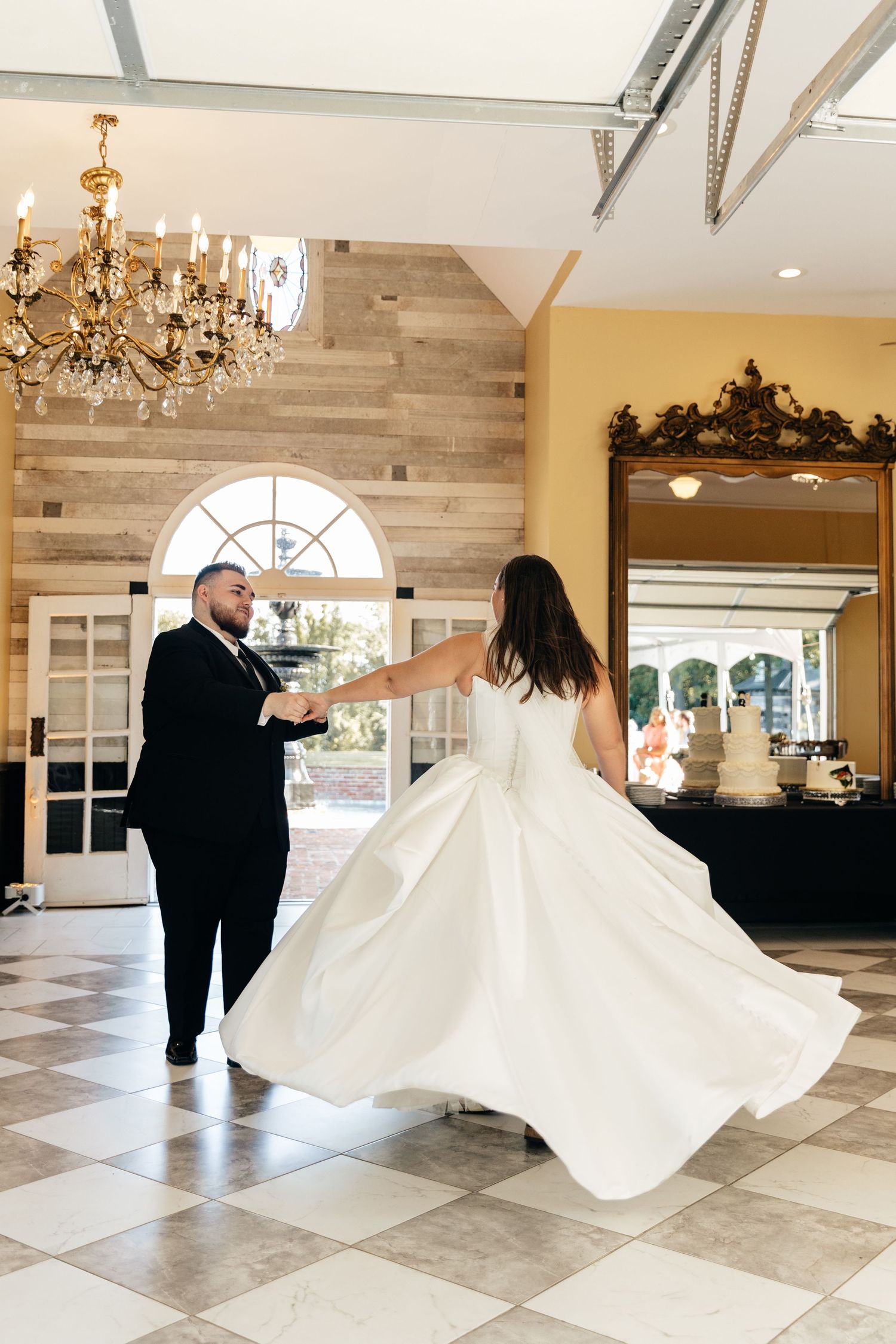 Wedding dance in elegant venue with marble floors and wooden accent walls.