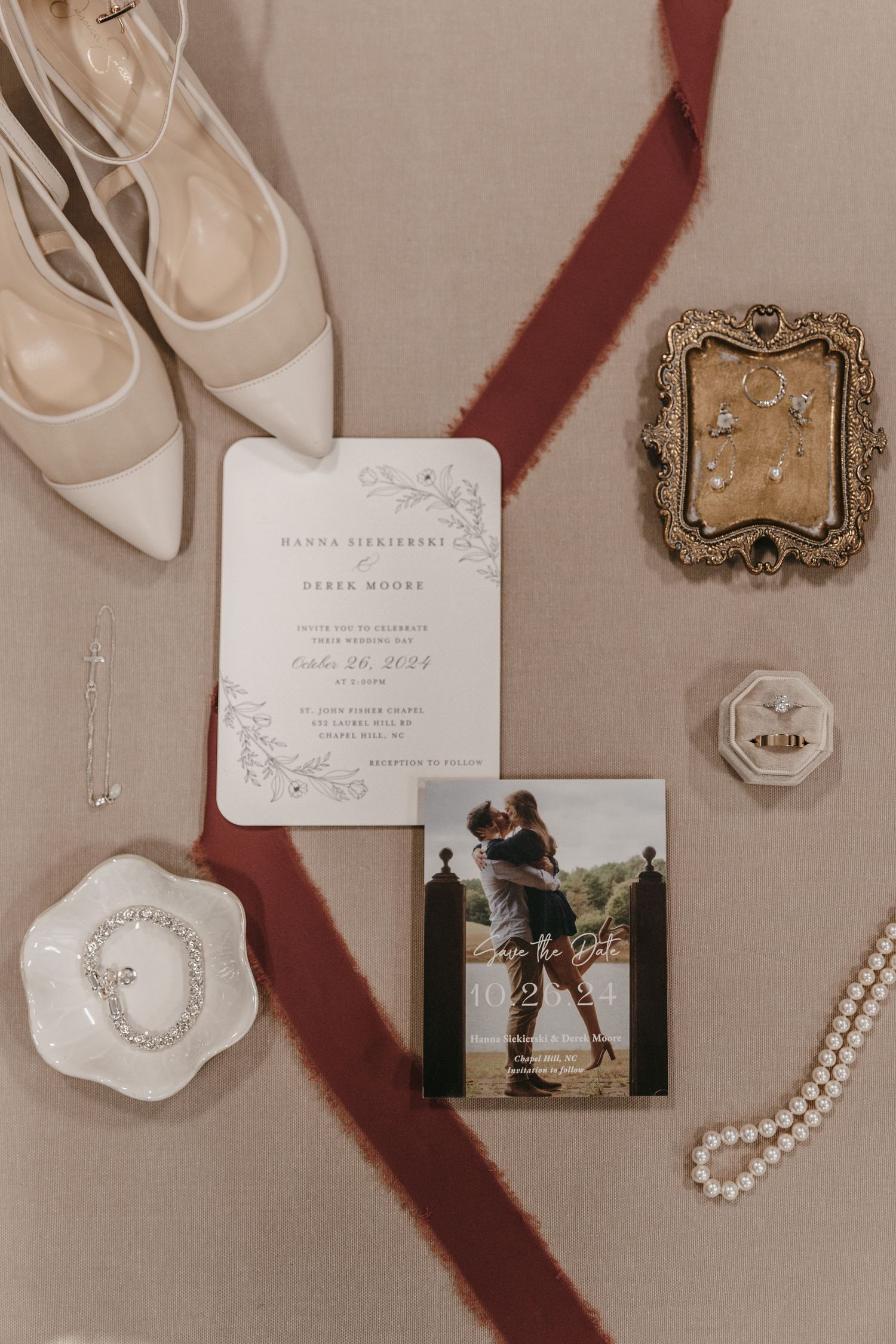 Wedding accessories including invitations, pearls, shoes, and photos arranged on neutral background.