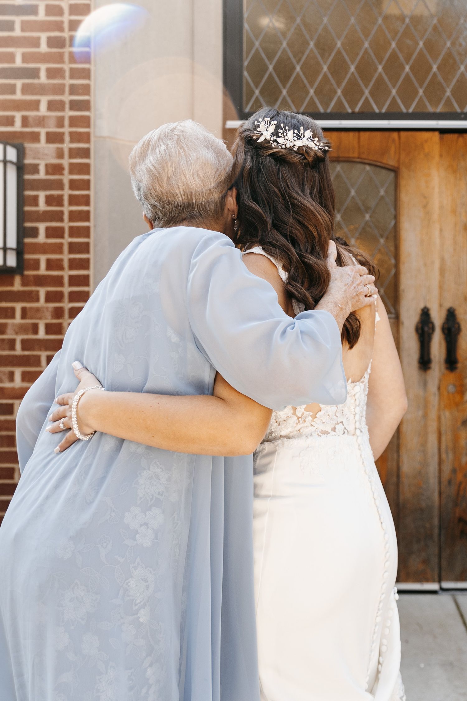 A tender embrace between a wedding guest and the bride after the ceremony.