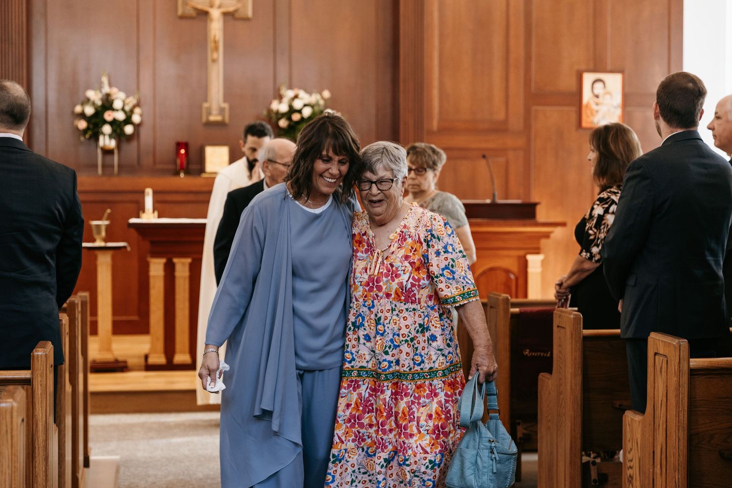 Wedding guests embracing after the ceremony inside the church.