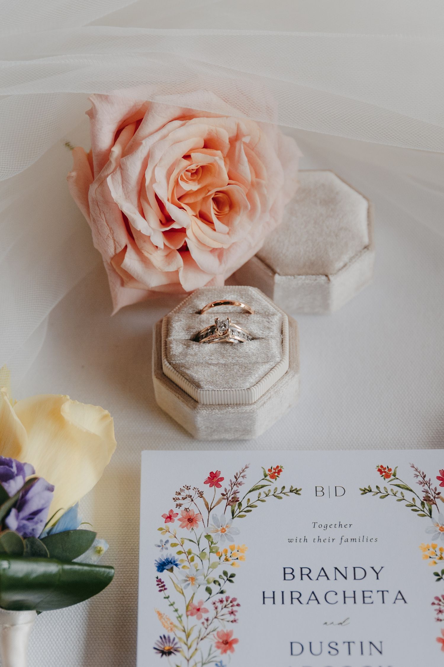 Wedding invitation suite with floral design and ring box decorated with pink roses.
