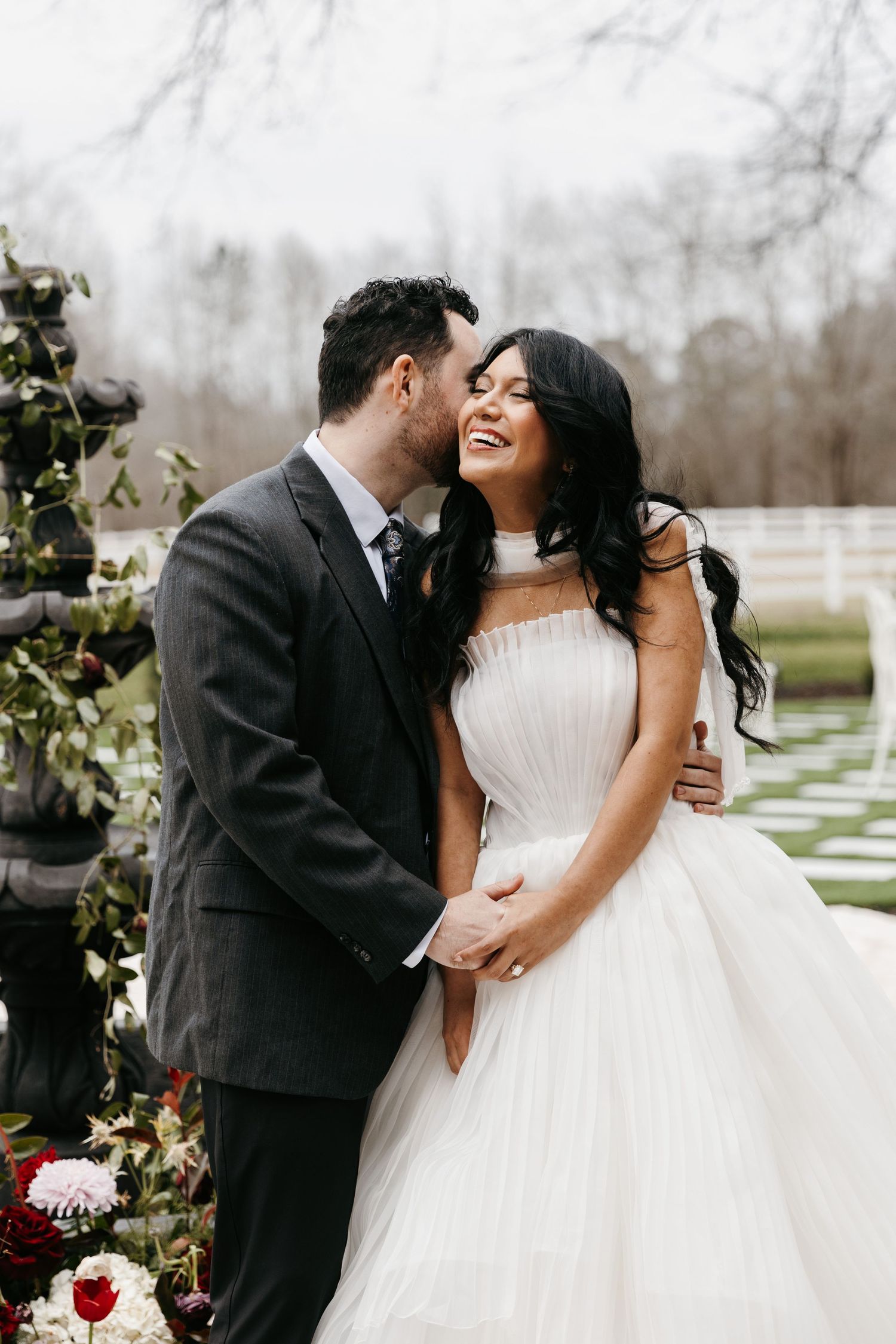 Romantic winter wedding portraits with floral decorations in the background.