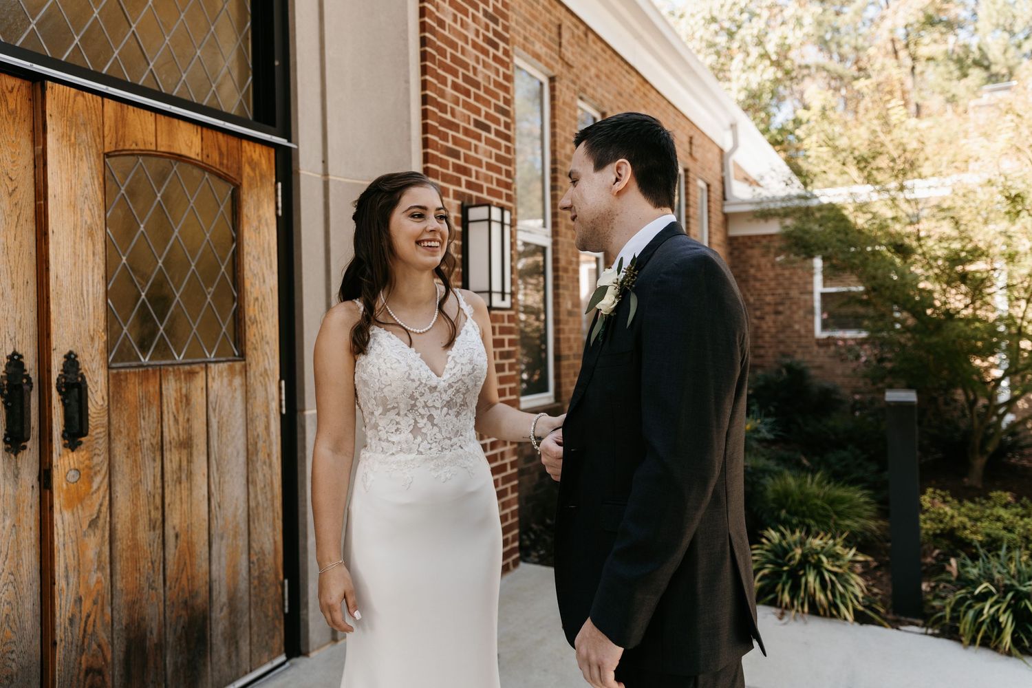 First look sequence at rustic venue with brick walls and wooden doors.