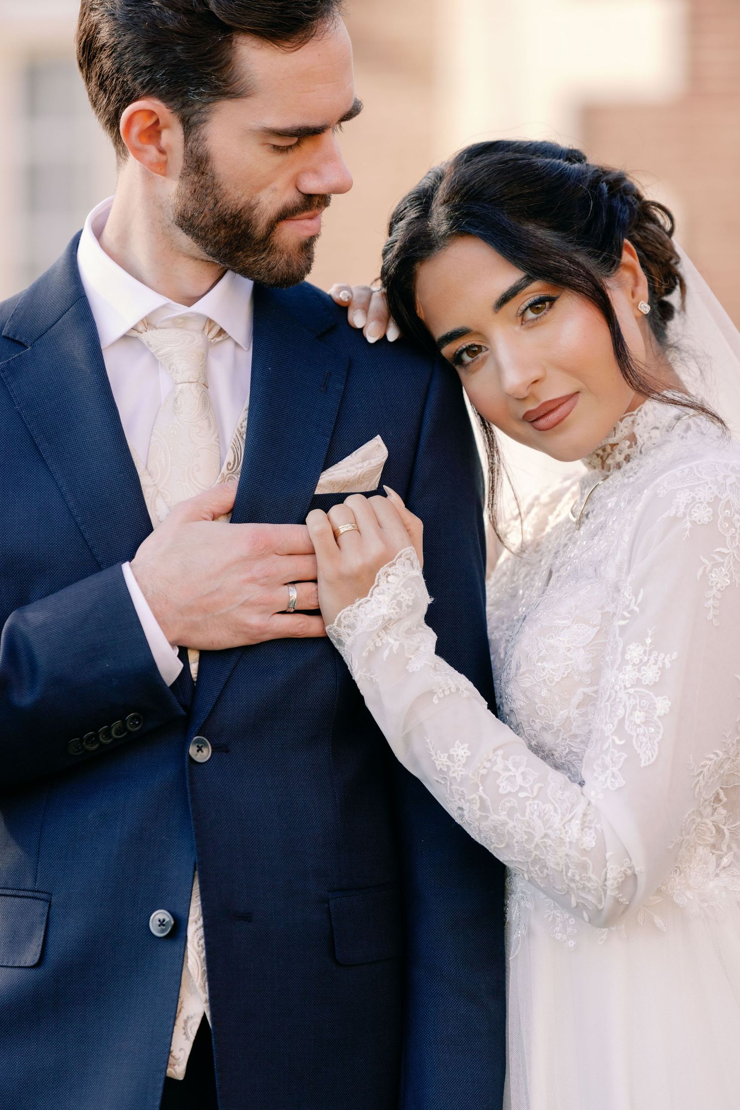 A romantic wedding photo collage showing tender moments between a couple in formal attire with lace and navy suit details.