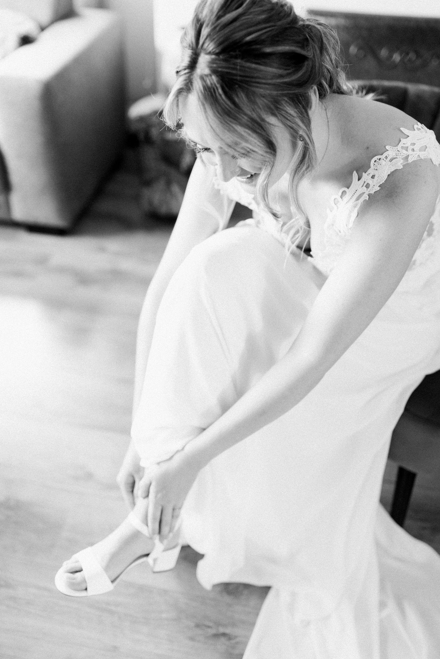 A series of black and white photos showing details of a bride getting ready in her wedding dress.