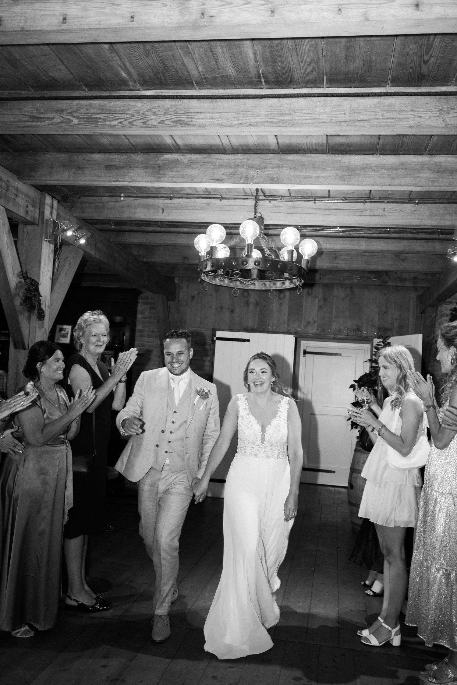 Wedding guests dancing and celebrating together in a rustic wood-paneled reception venue.