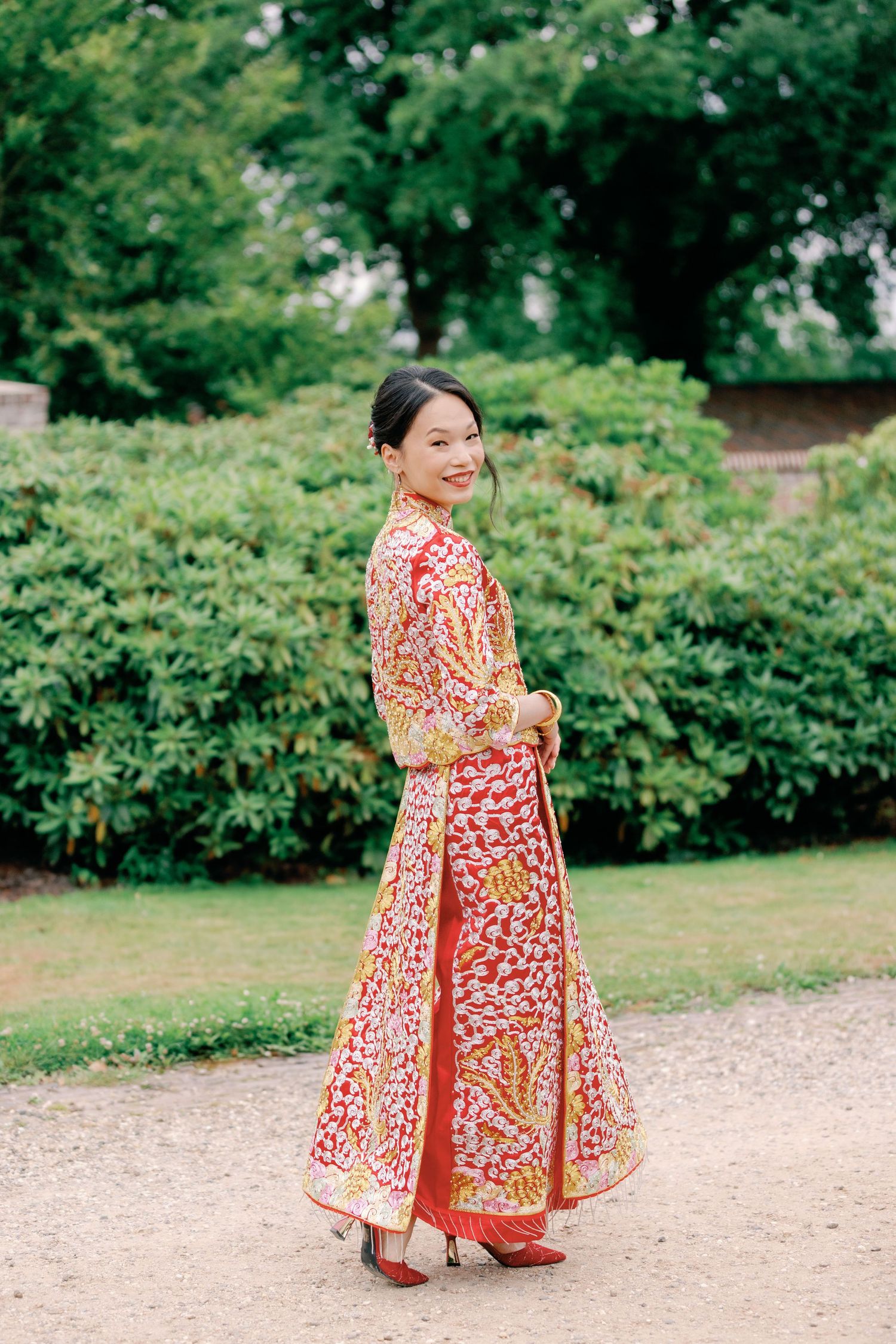 A sequence of images showing a person in a vibrant red and white floral dress twirling on a garden path.