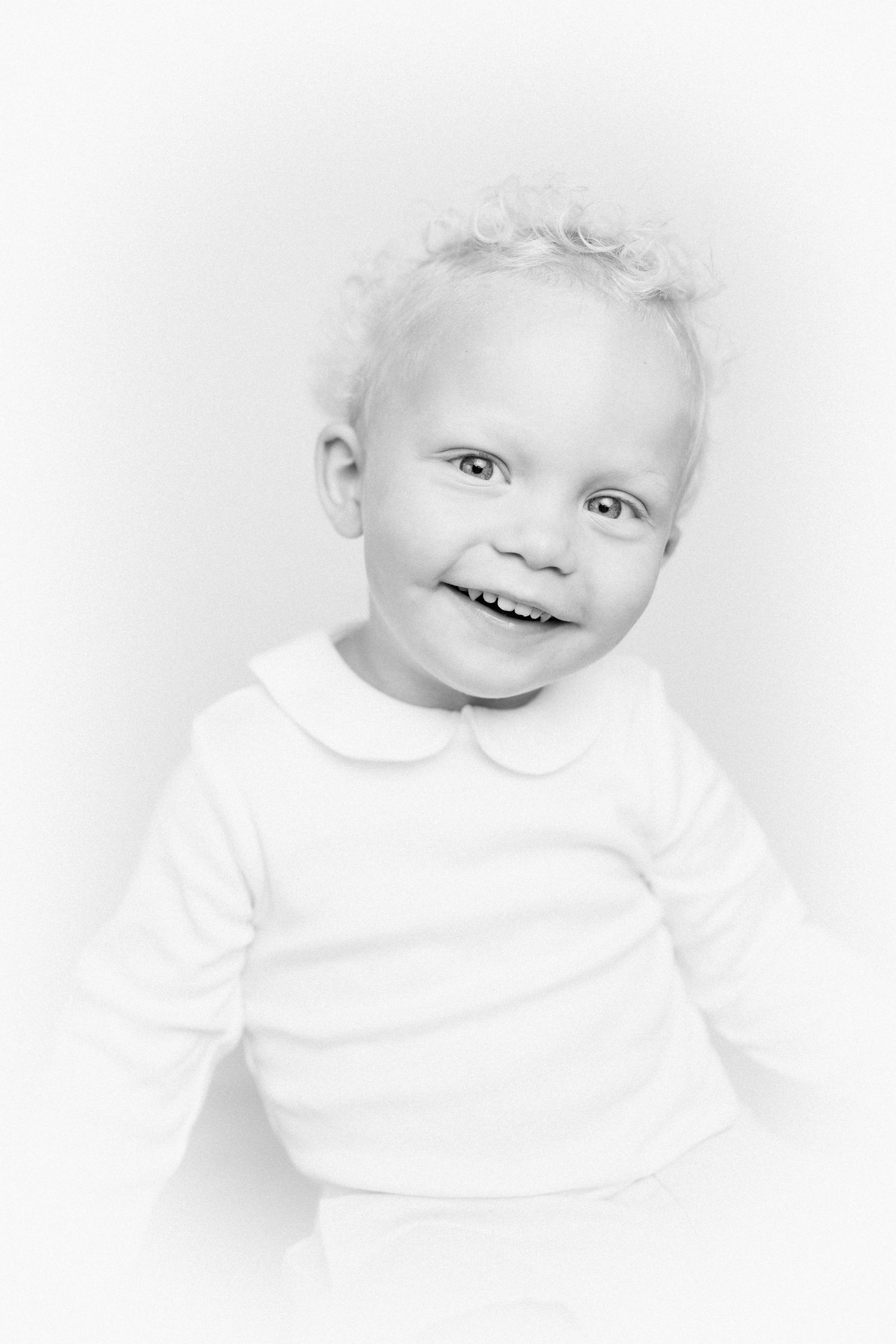 Artistic black and white portrait series of a small child wearing white.