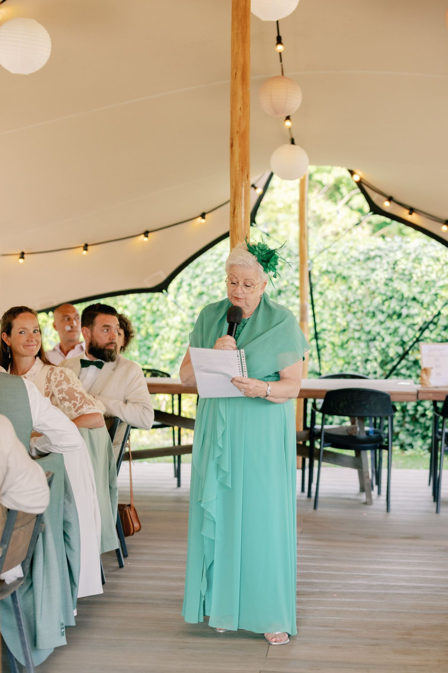 Four sequential photos show a couple dancing together on a wooden deck under a tent with teal and white attire.