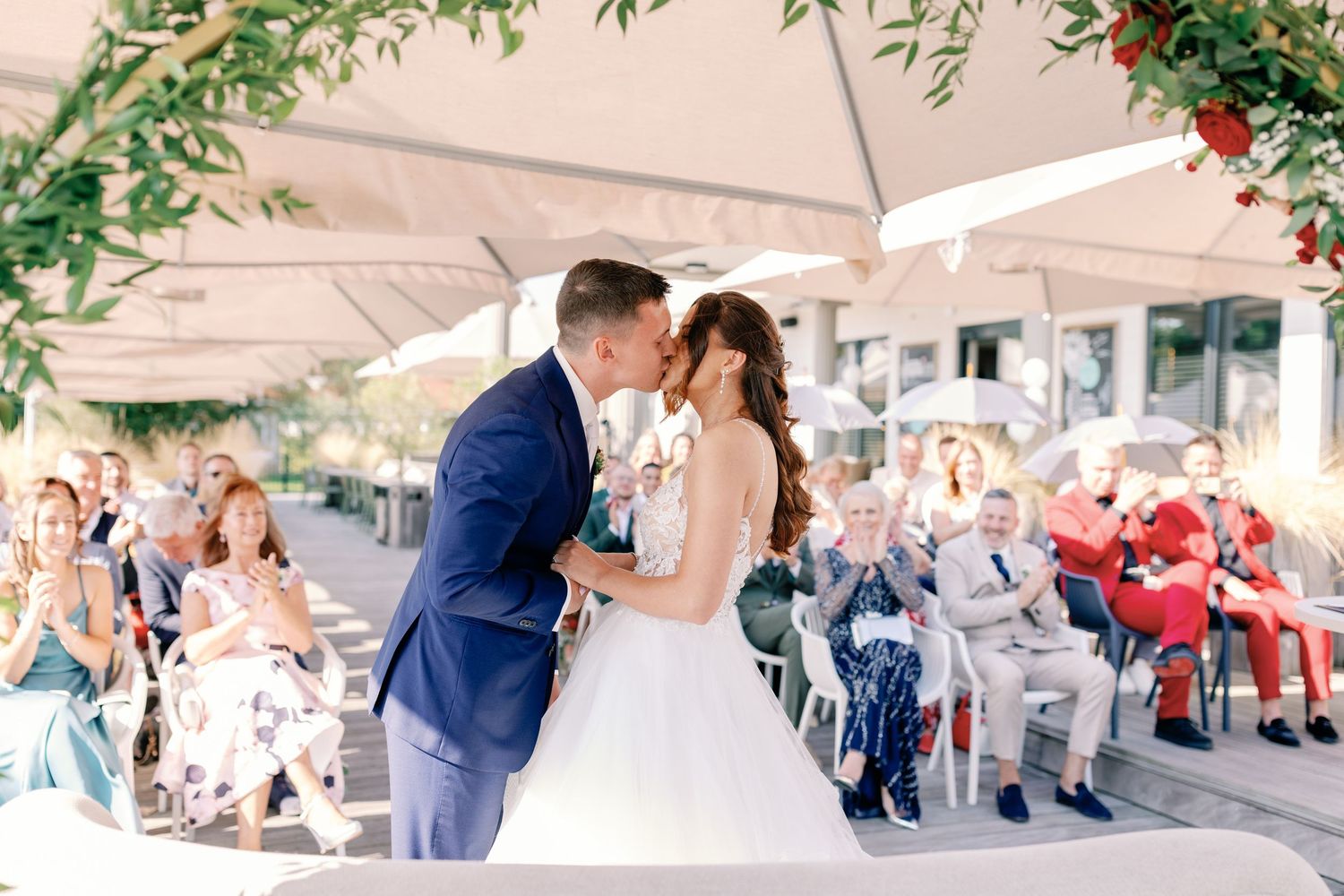 A joyous wedding moment captured under a white canopy as guests celebrate the newlyweds.