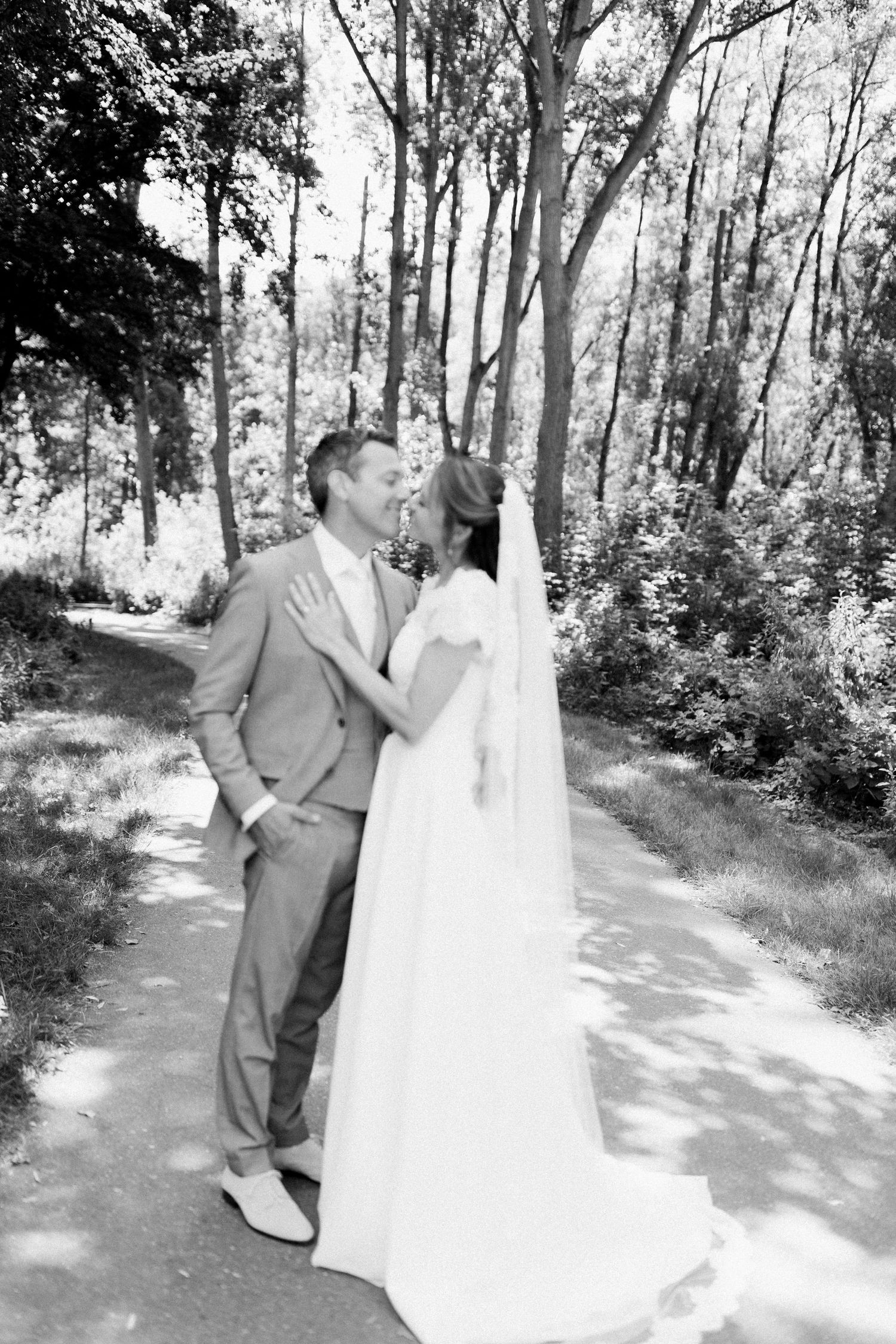 A romantic wedding photo sequence shows a couple in formal attire sharing tender moments along a sunlit wooded path.