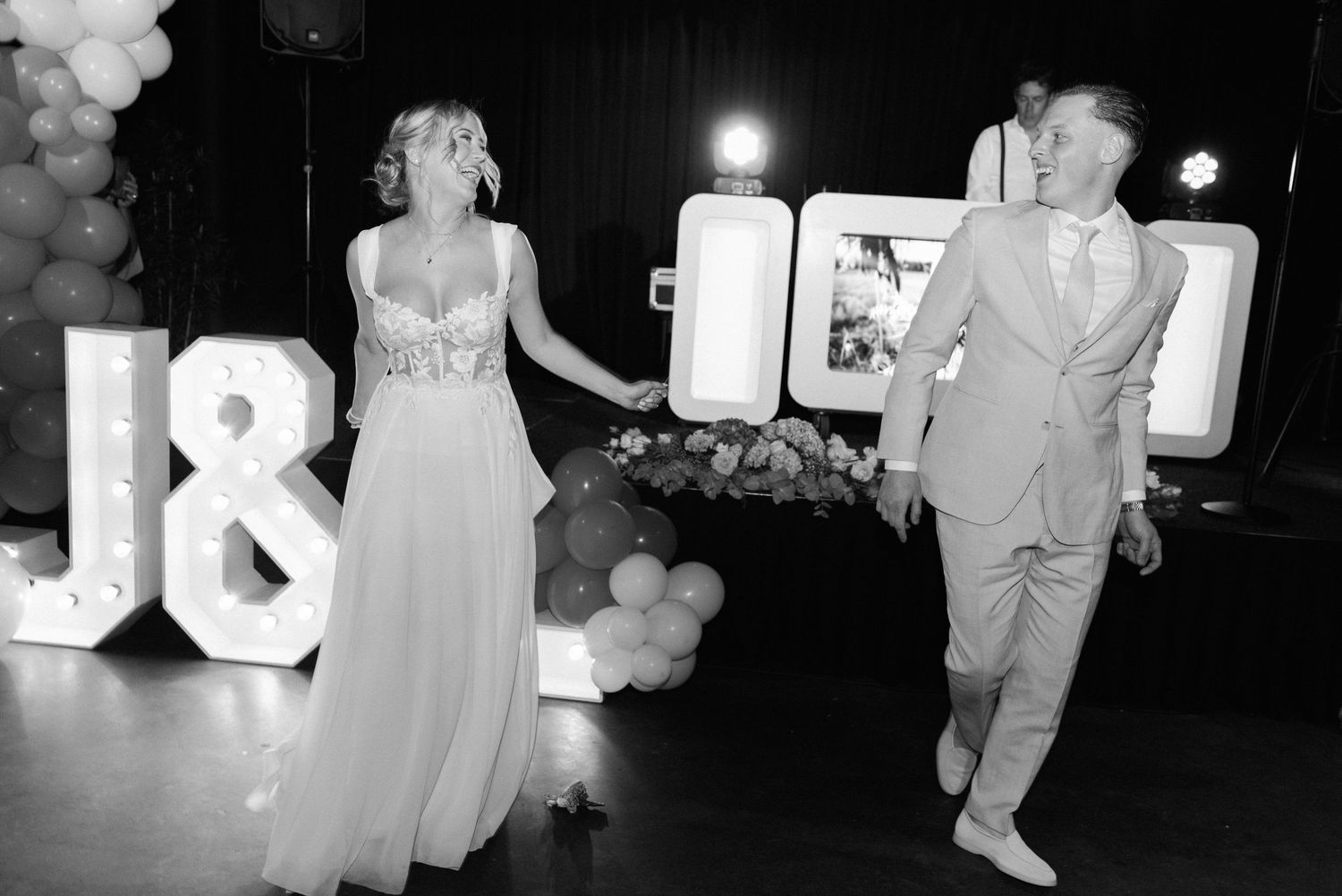 Black and white photo of a couple dancing at an 18th birthday celebration with balloons and decorative lighting.