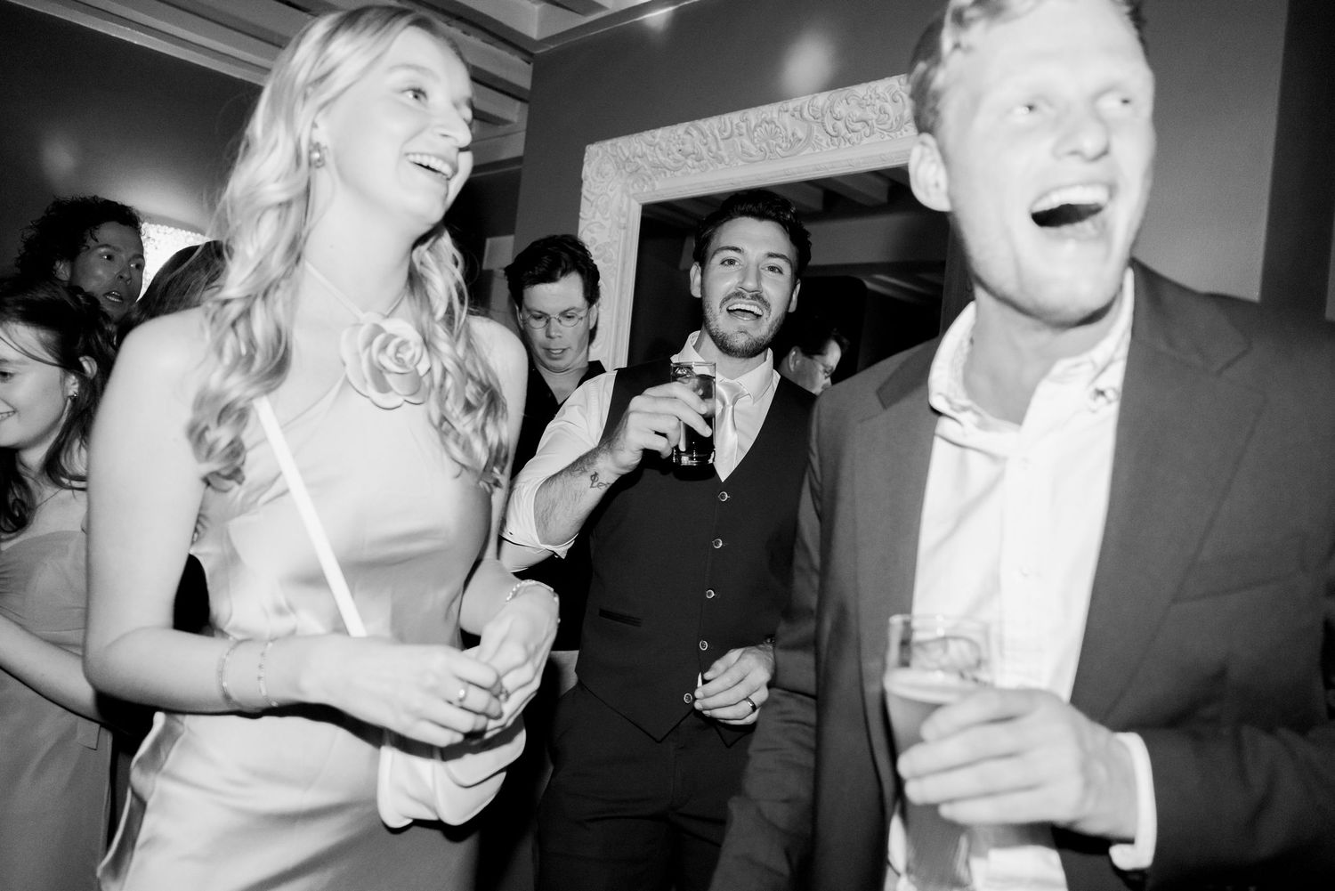 Black and white photos show joyful dancing and laughter at a wedding reception celebration.