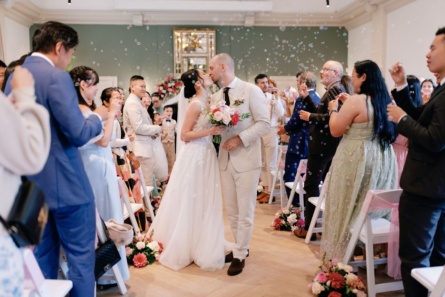 Wedding guests dance and celebrate together on an elegant ballroom dance floor during a joyful reception.