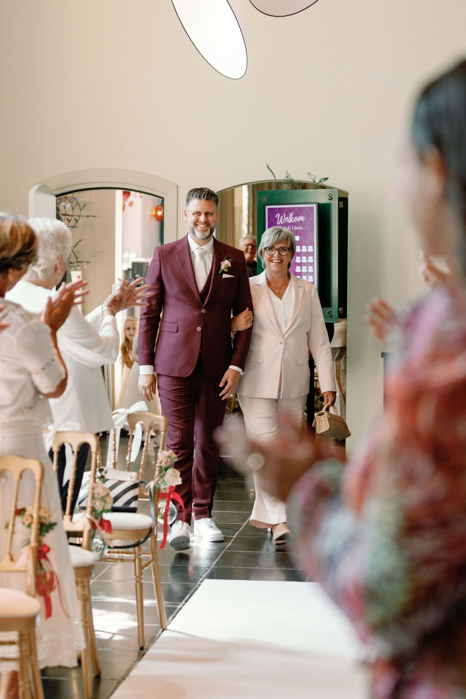 Wedding guests dance and celebrate on a dance floor at a reception venue.