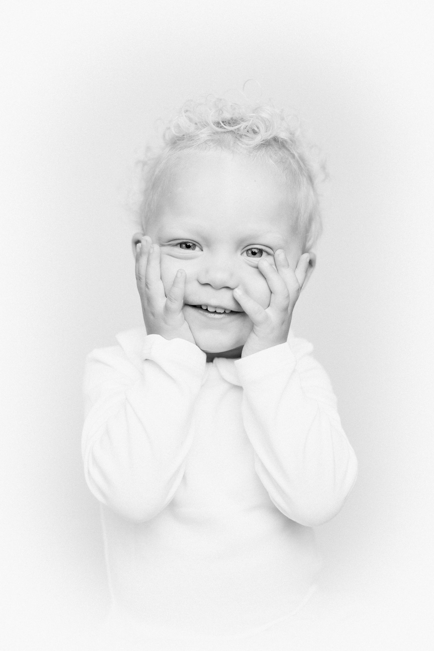 Sweet black and white portrait of a baby making playful expressions.