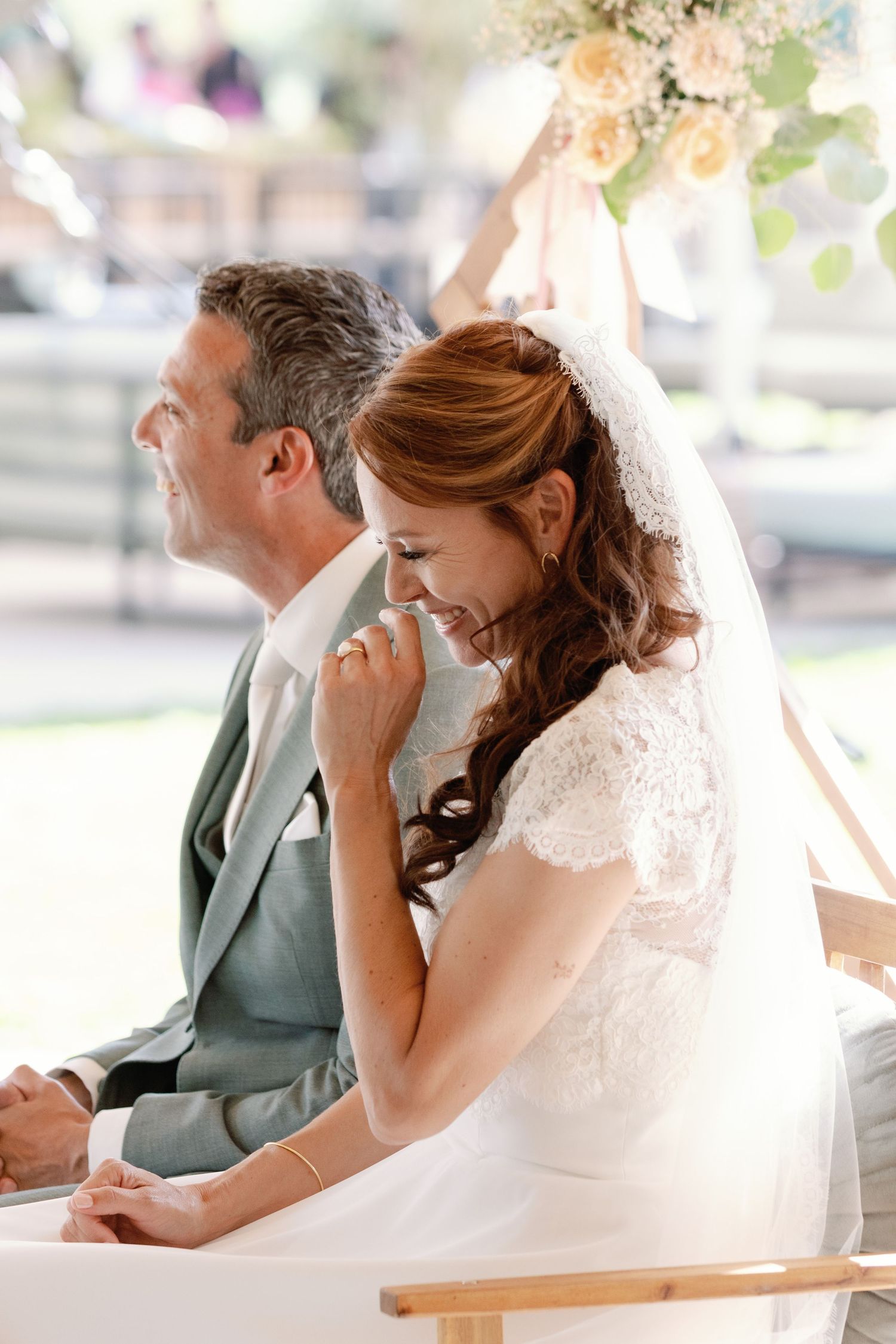 A bride and groom share an emotional moment while sitting together at their wedding reception.