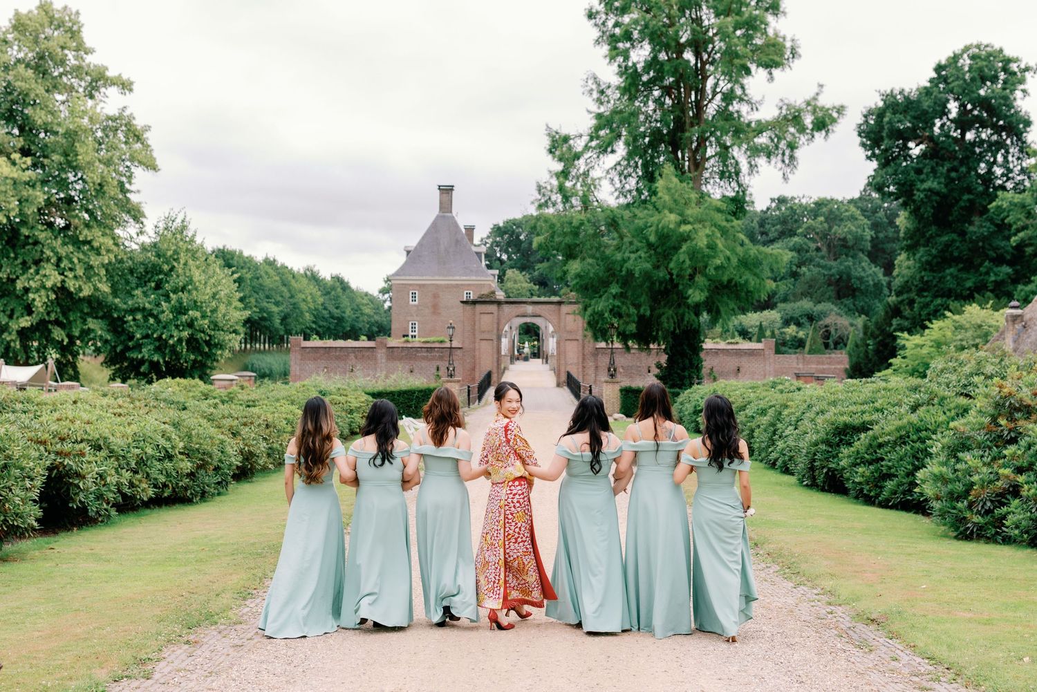 A sequence of wedding party photos showing bridesmaids in light blue dresses walking together on a green lawn.