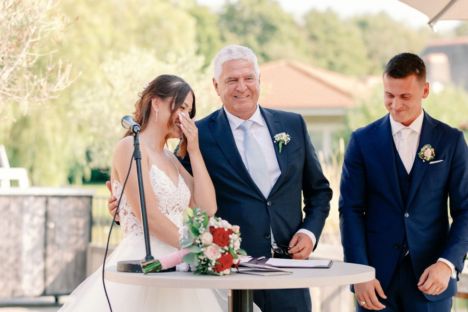 Wedding party poses for formal photos during outdoor celebration.