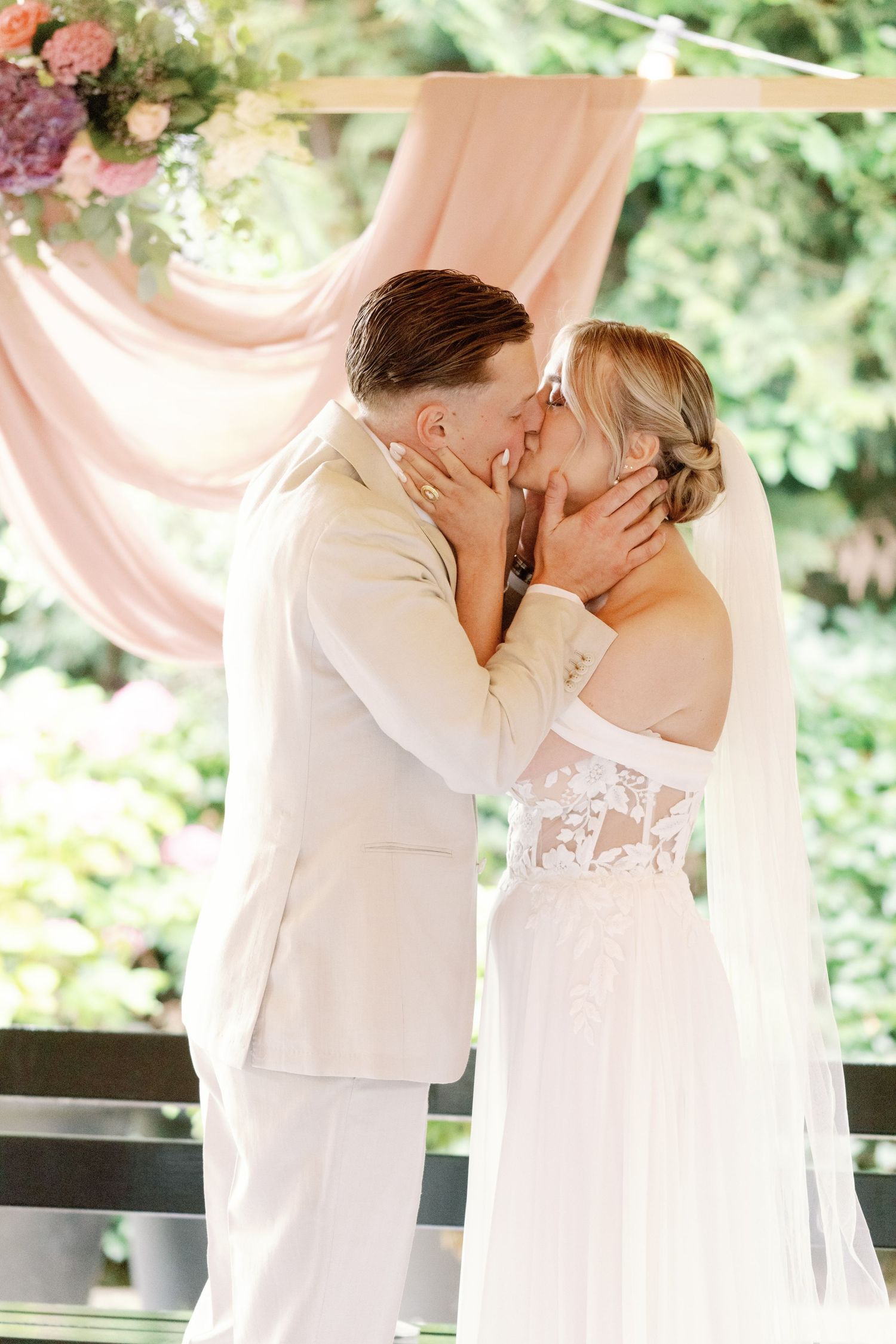 A romantic wedding kiss sequence showing a couple in white attire sharing tender moments under soft lighting outdoors.