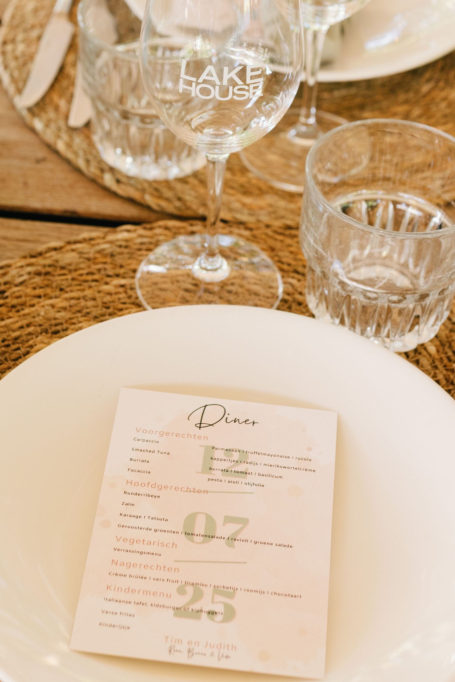 Elegant table setting with crystal glassware and printed menu cards at a formal dining event.