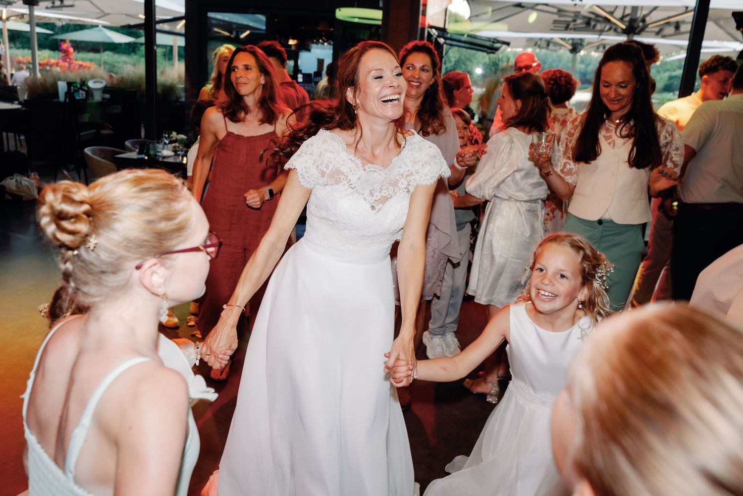 Wedding guests dance together during a lively reception celebration on the dance floor.