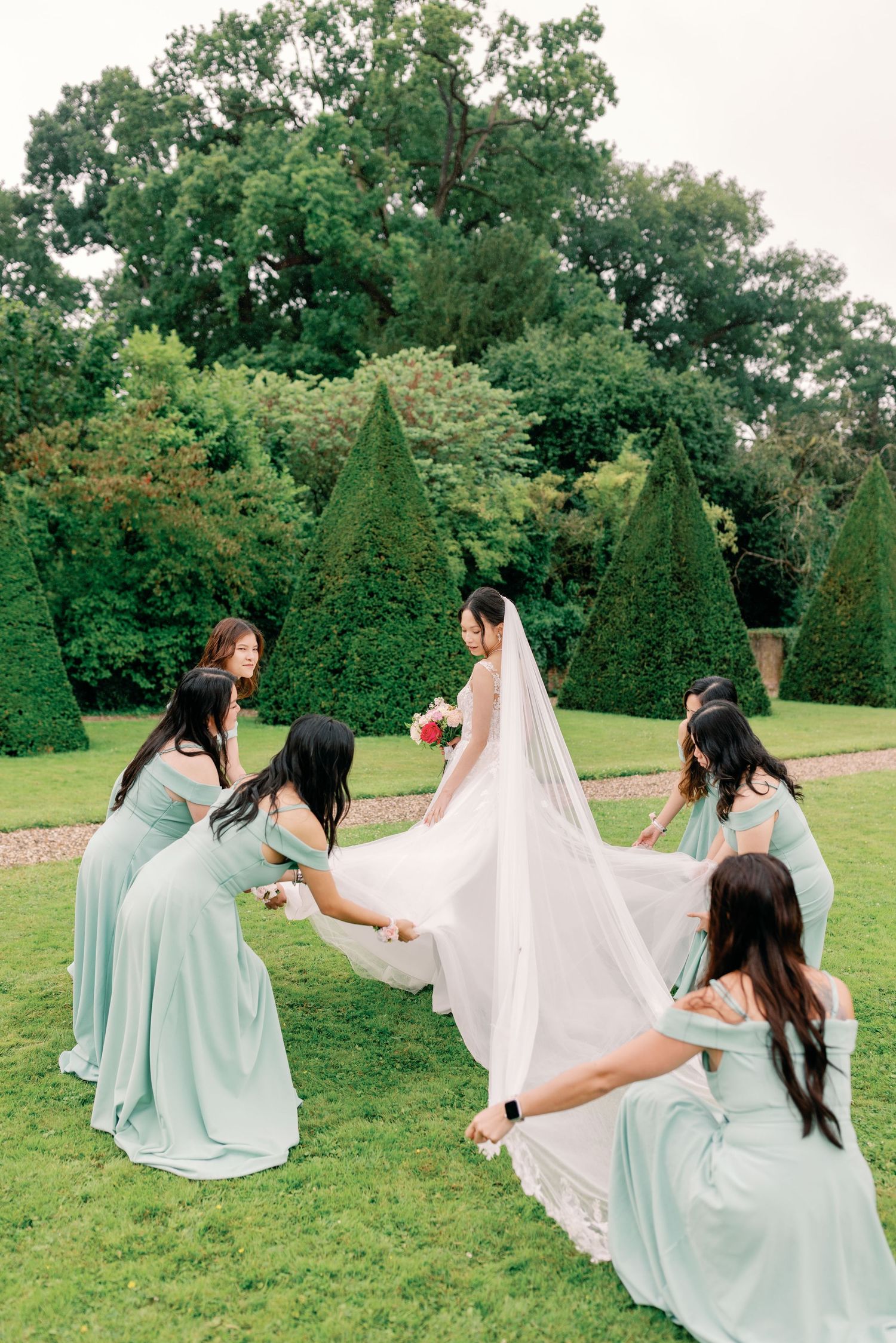 A sequence of five photos showing bridesmaids in mint green dresses dancing with the bride's veil in a garden setting.