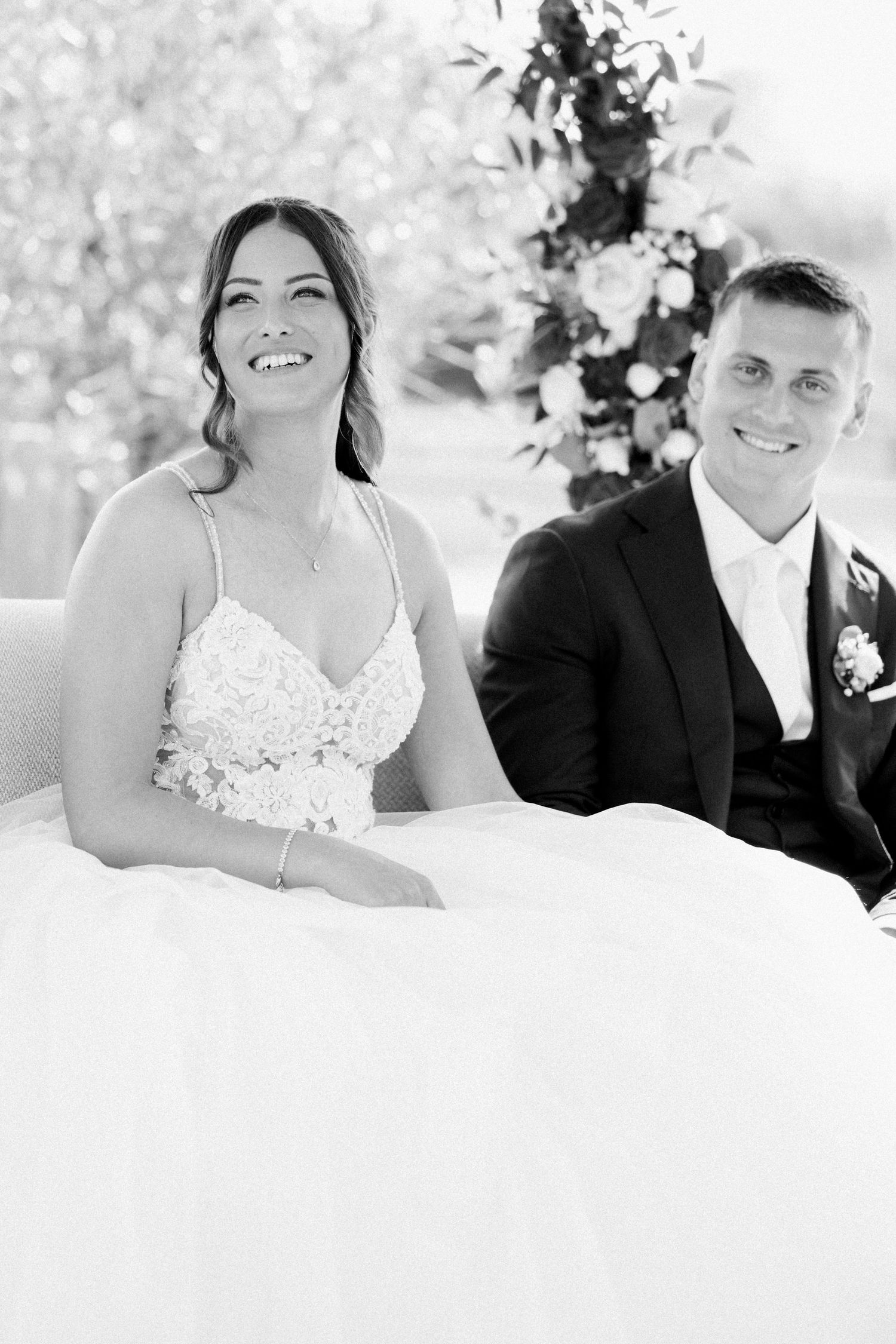 Black and white wedding portraits of a couple sitting together and smiling.