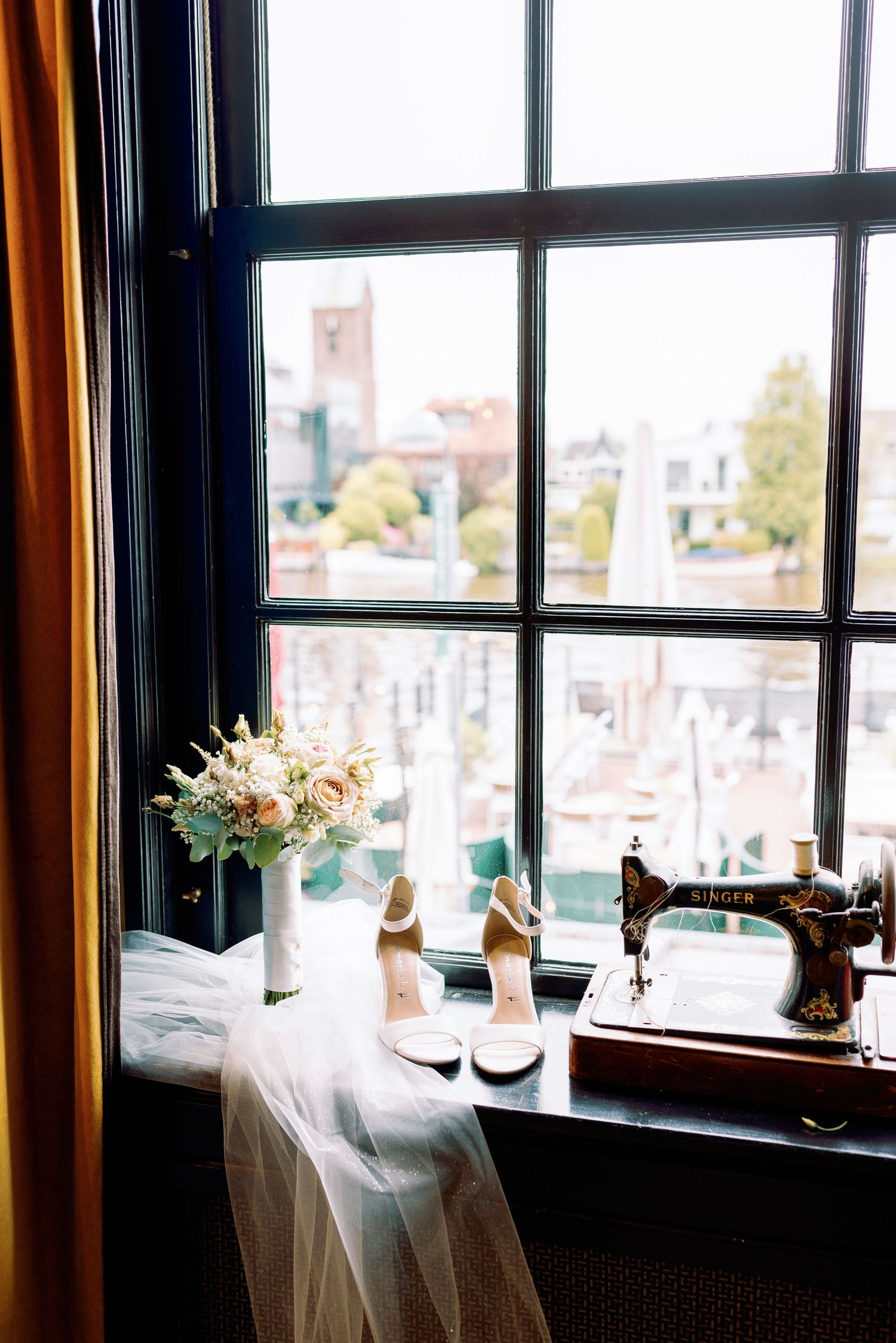 Elegant restaurant table settings near large windows with city views and natural light streaming in.