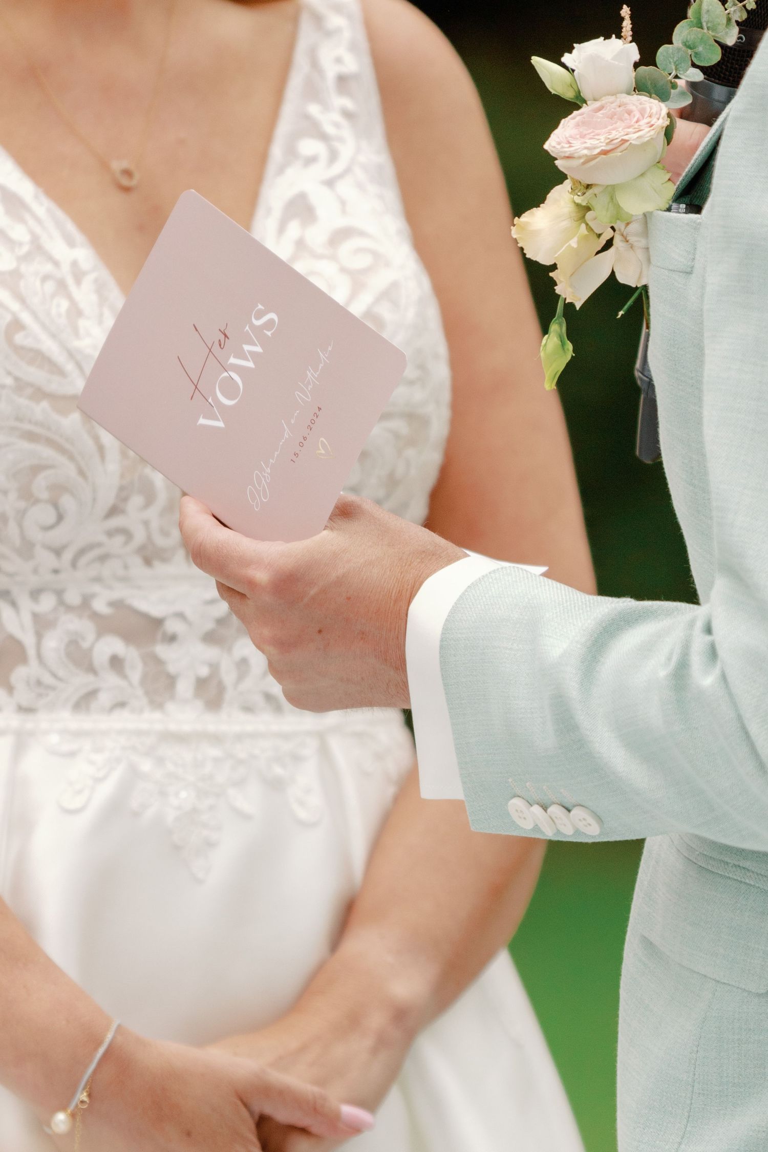 A couple exchanges vows and holds wedding ceremony programs in a romantic outdoor garden setting.