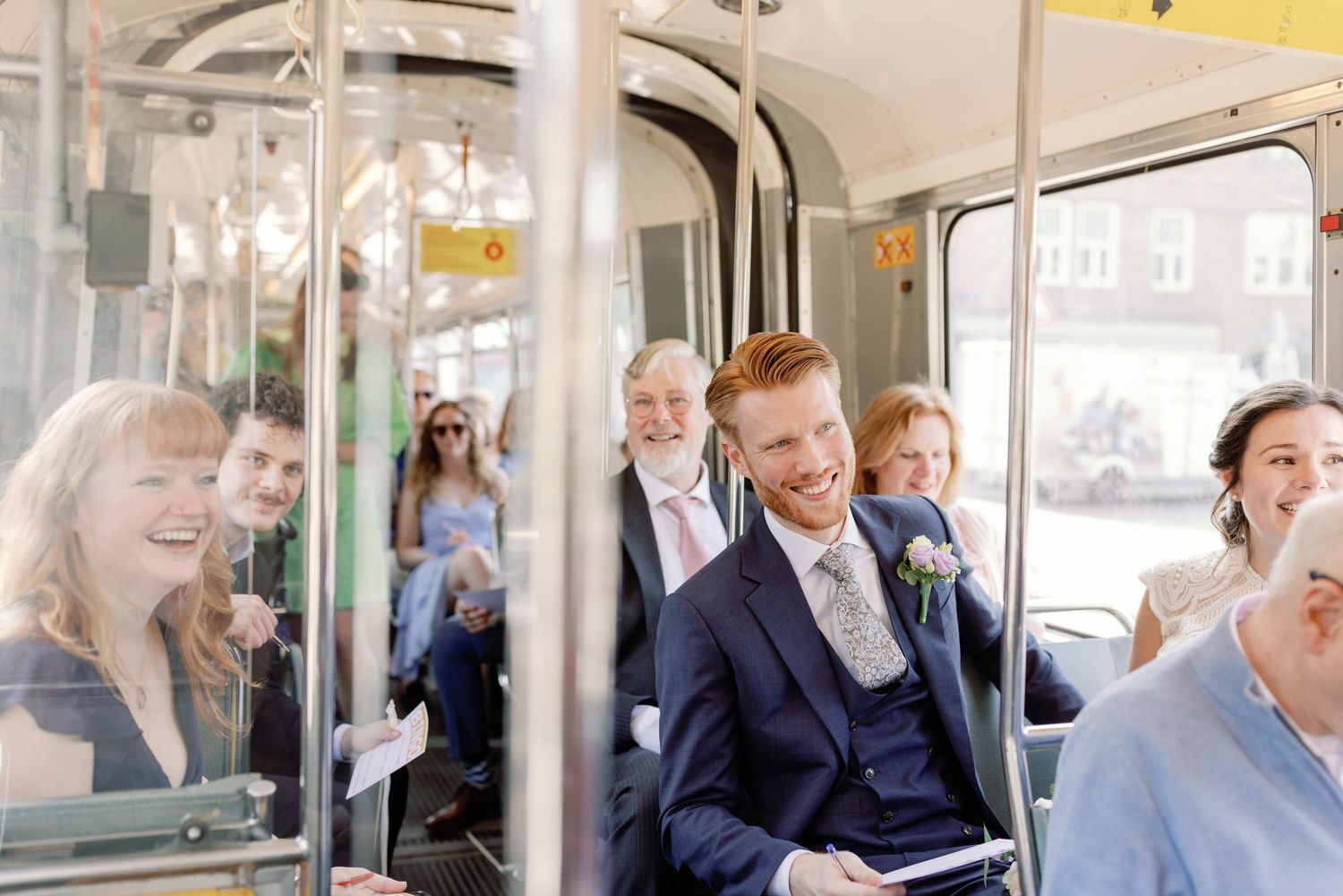 Passengers share joyful laughter while riding together on public transit in black and white photography.