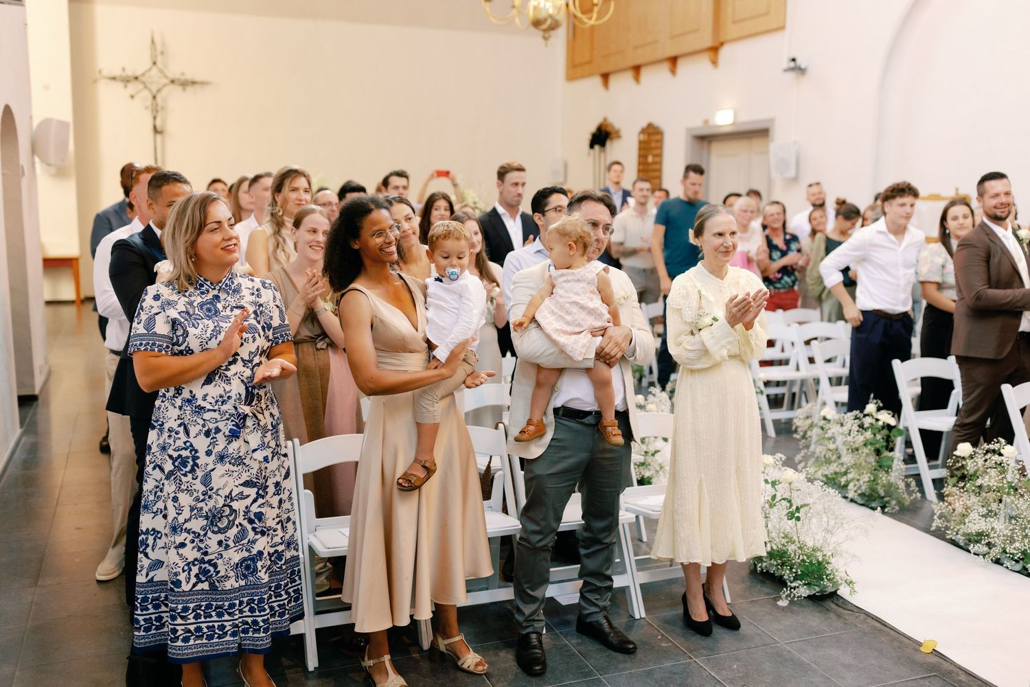 A series of wedding photos showing guests and wedding party members in formal attire at an indoor venue.
