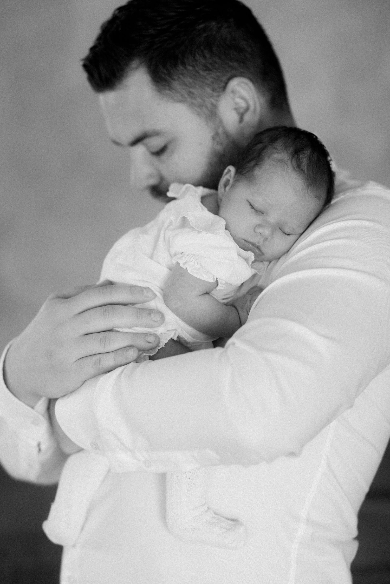 Black and white series of tender moments between parent and newborn.