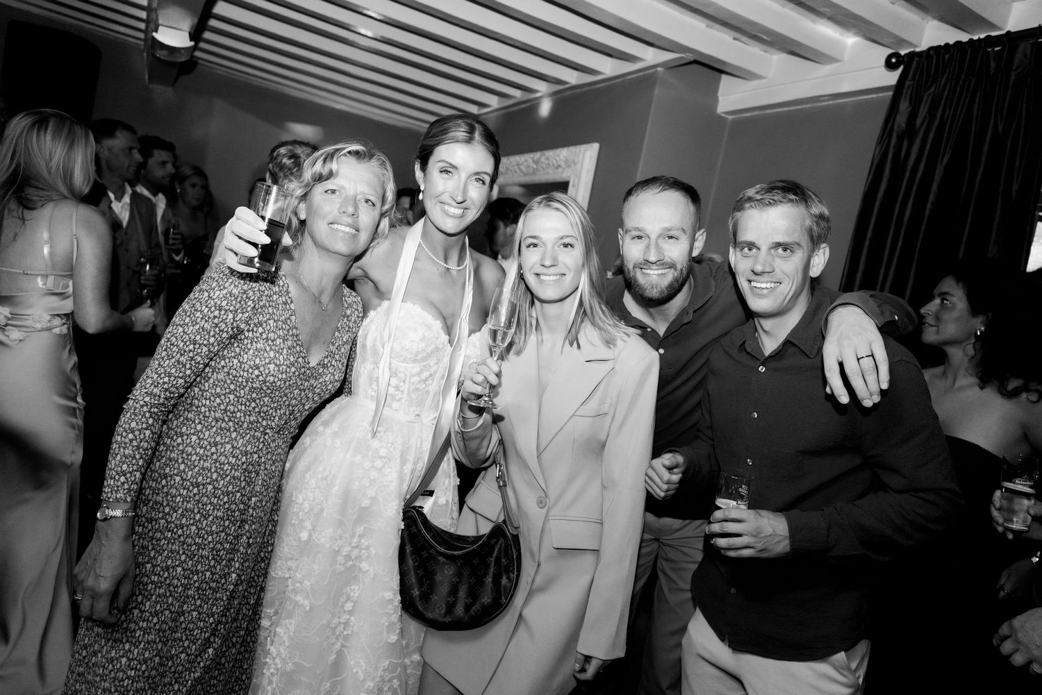 Group of people socializing and enjoying drinks at what appears to be a party or nighttime gathering.