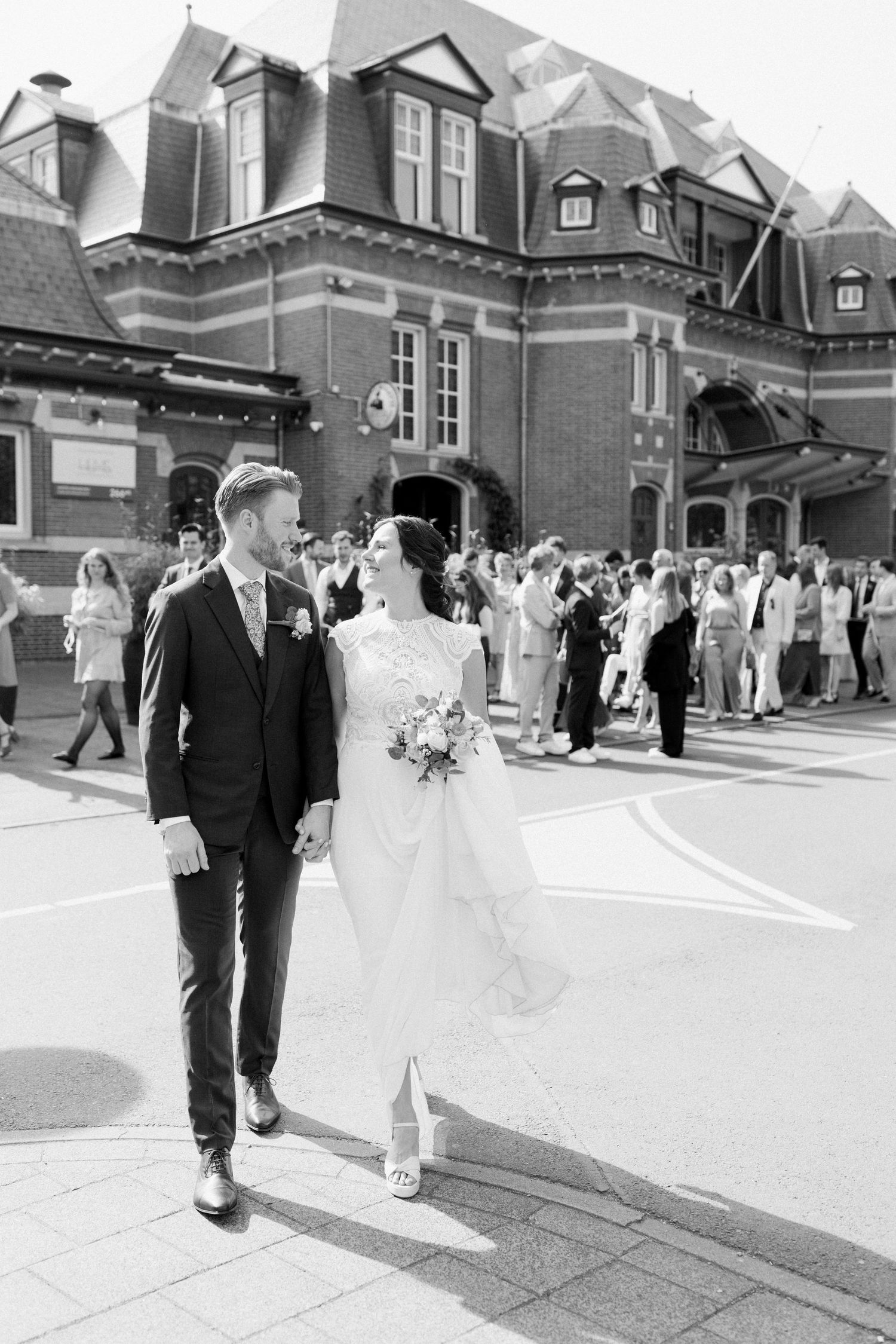 Black and white wedding photos showing couples walking outside a brick church building with elegant architecture.