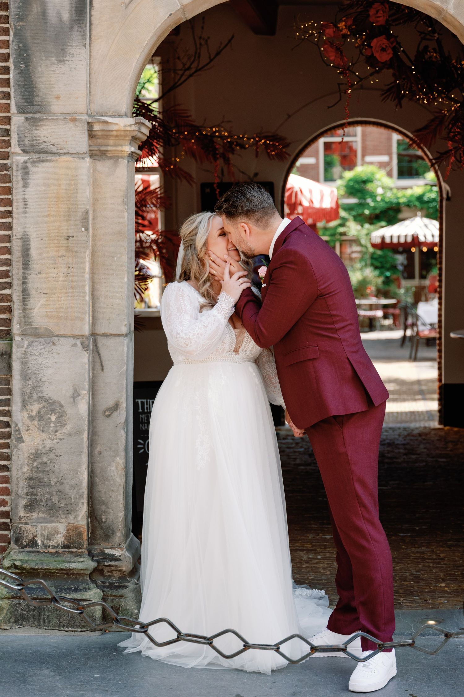 A romantic wedding couple shares intimate moments under a stone archway in a series of connected photos.