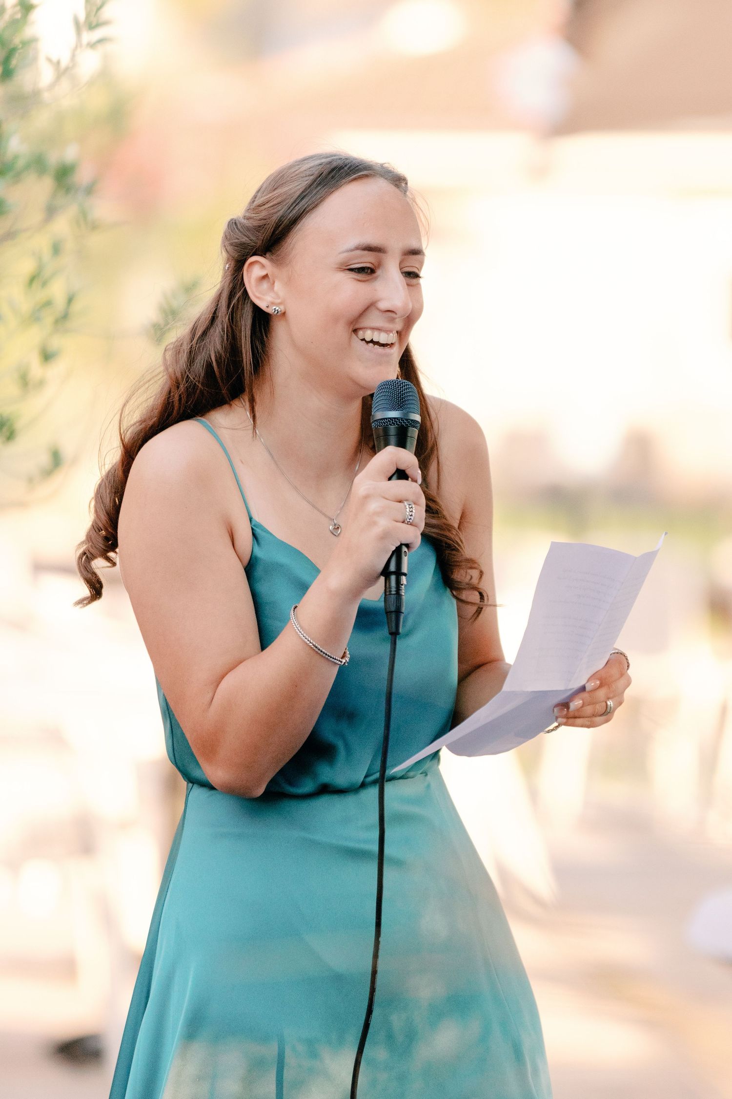 Speaker delivering emotional speech at outdoor wedding reception.
