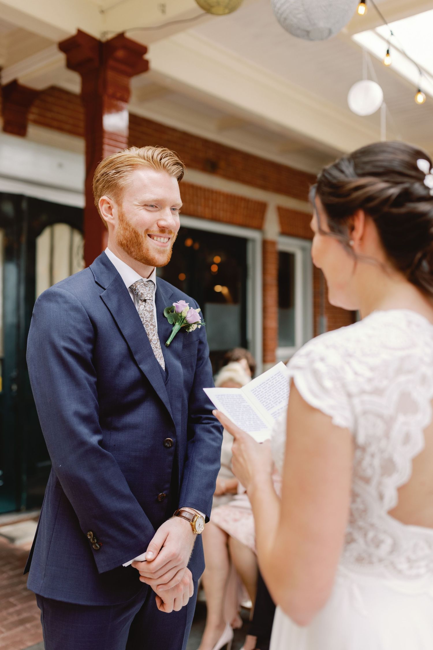 A bride and groom share a joyful first look moment on their wedding day in an elegant indoor setting.