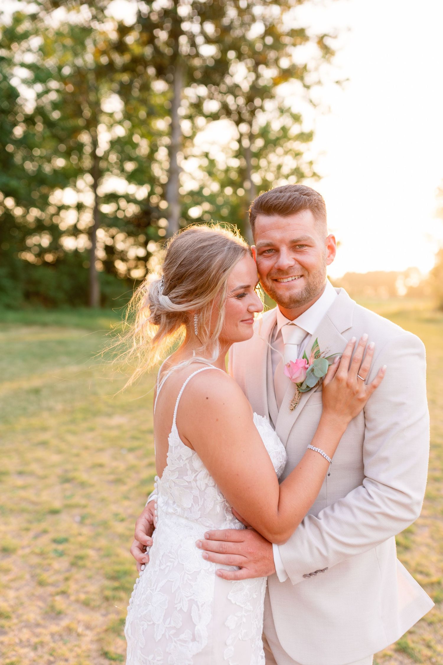 A romantic sunset portrait of newlyweds embracing outdoors.