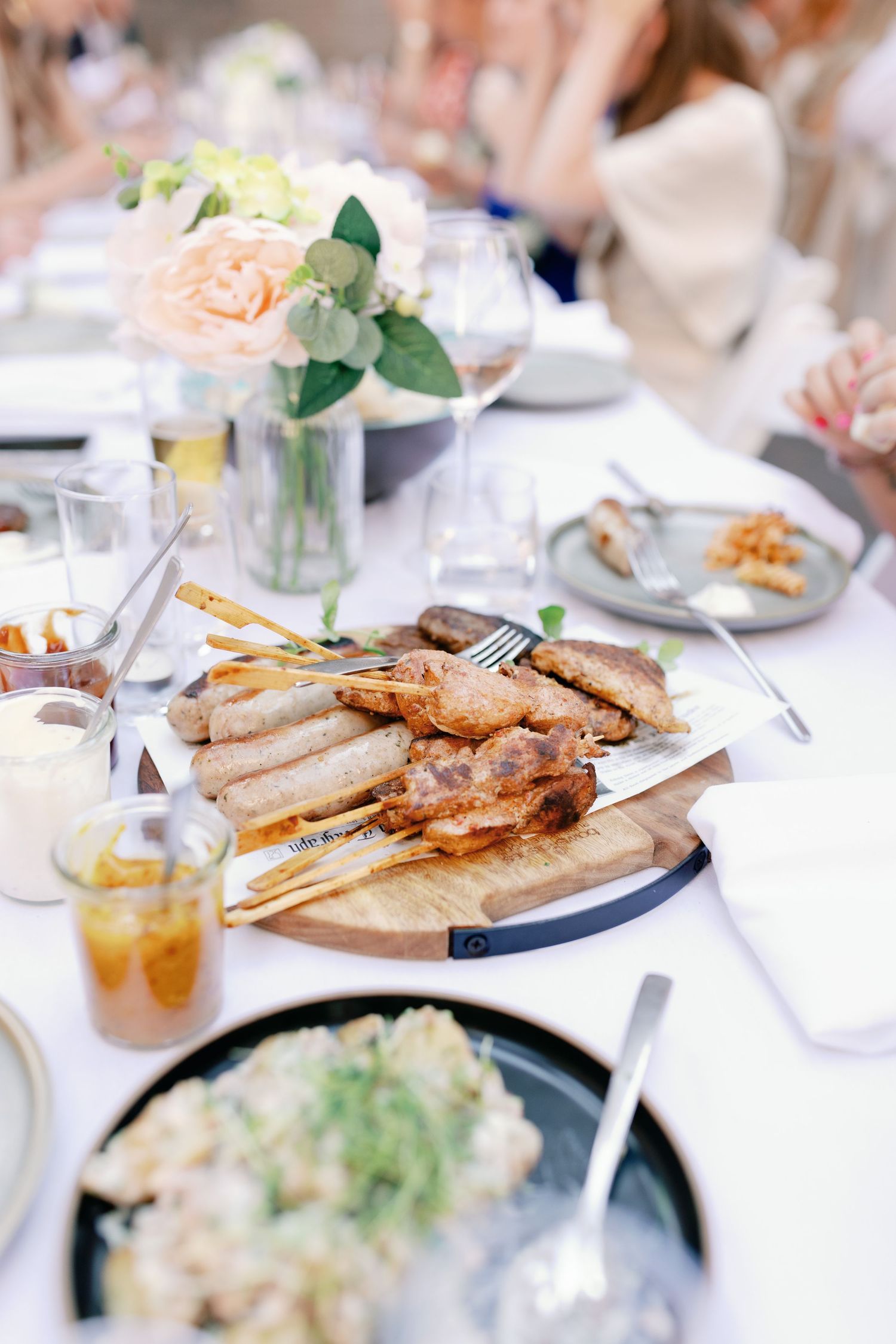 Table setting with plates of grilled sandwiches and salads at a casual restaurant lunch gathering.