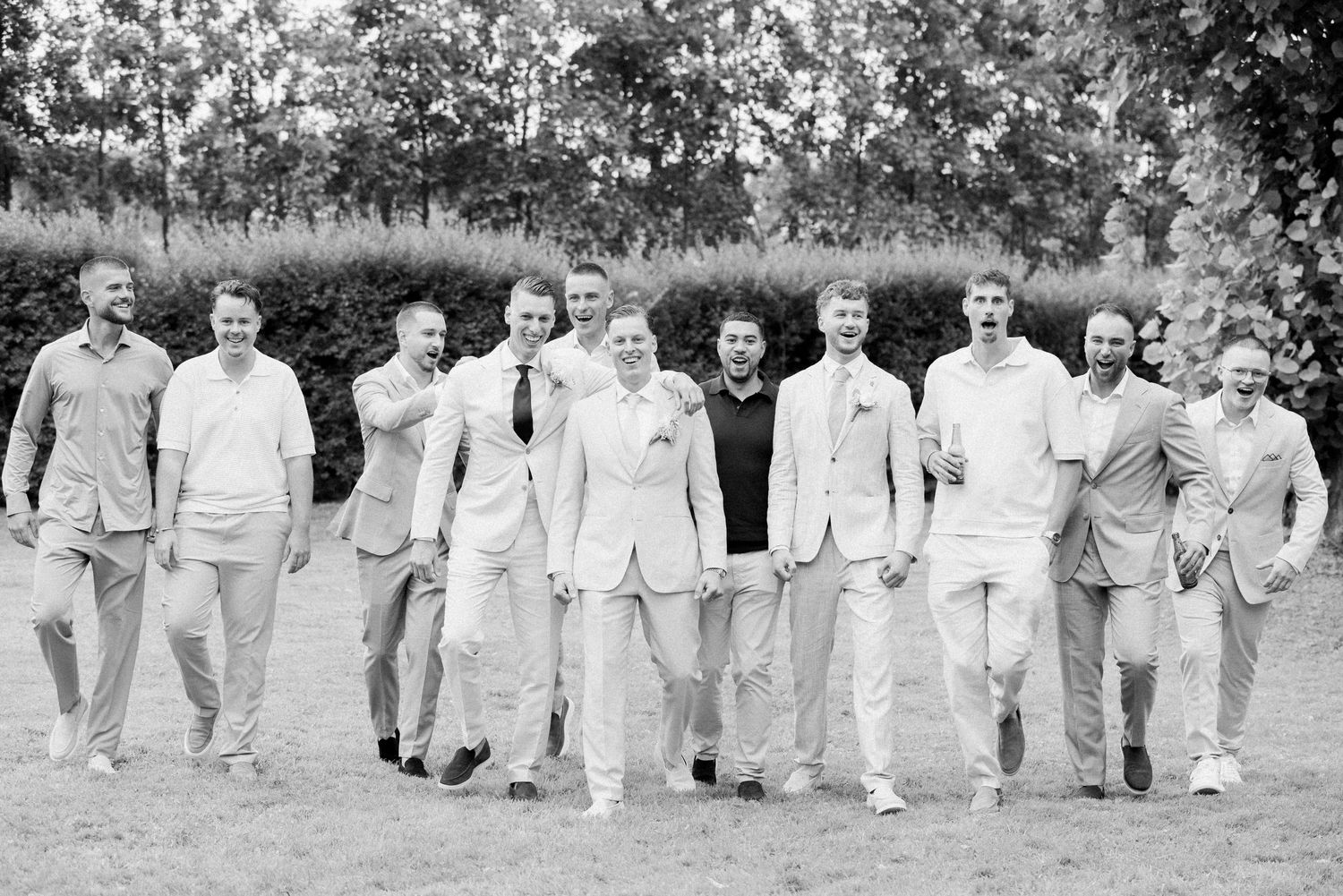 A vintage black and white panoramic photo showing a large group of people walking together outdoors.