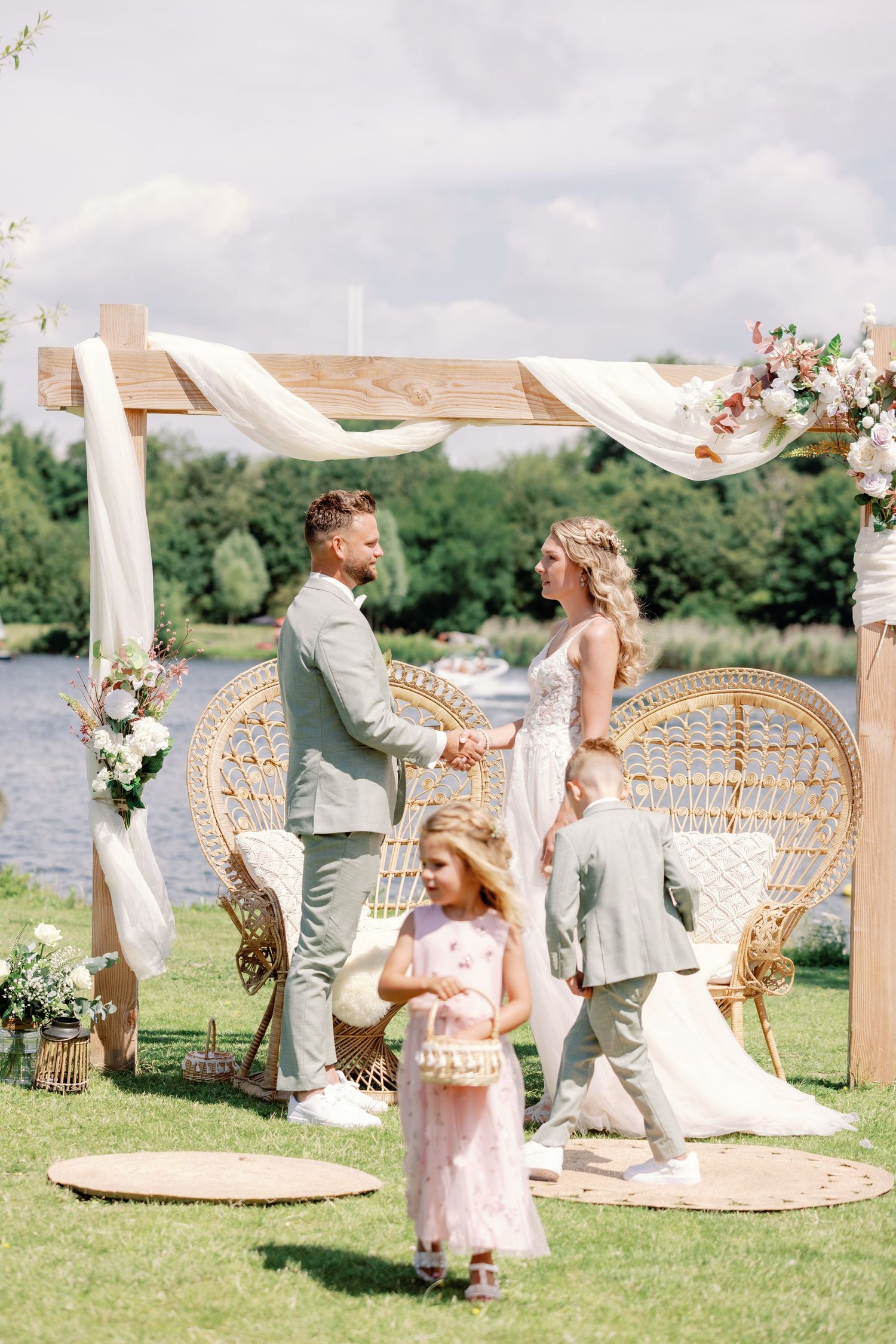 Elegant outdoor wedding ceremony setup with peacock chairs and white draping fabric creating a romantic atmosphere.