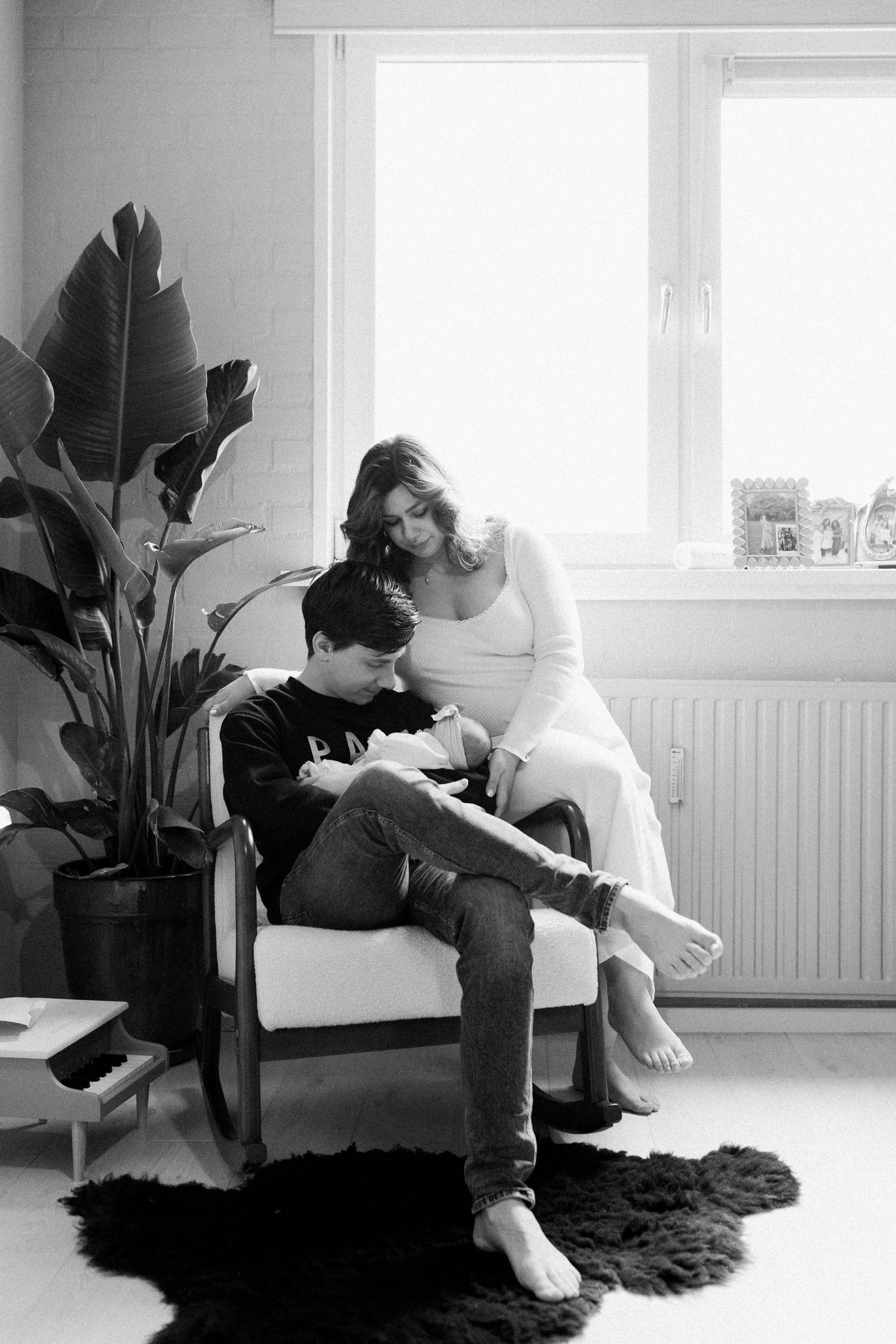 Minimalist black and white photos showing figures relaxing in a bright room with large windows.