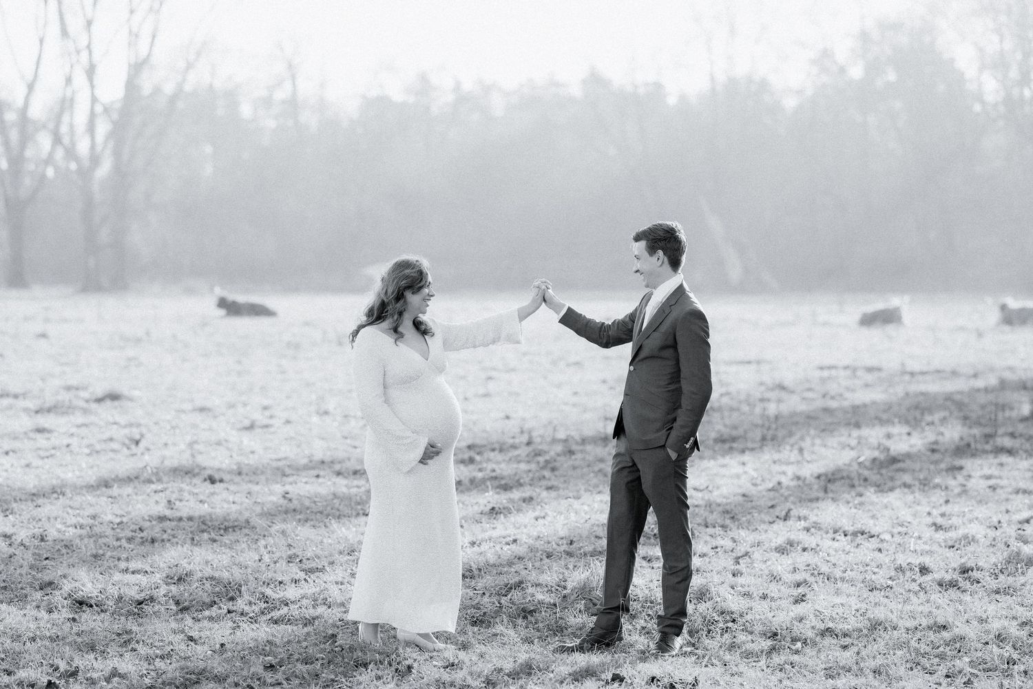 Couple poses in a misty field during their romantic wedding photoshoot.