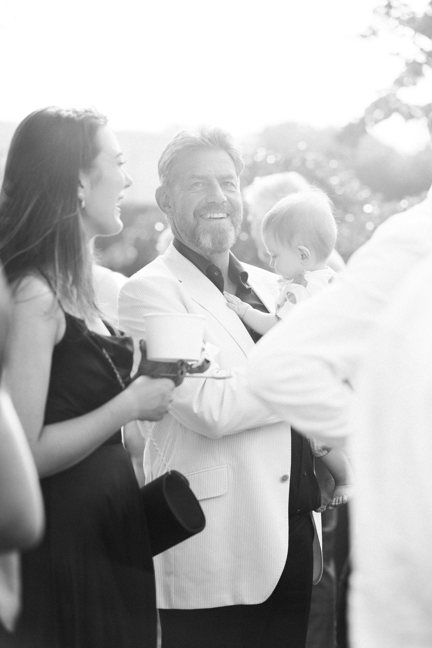 Black and white candid moment during outdoor wedding celebration.
