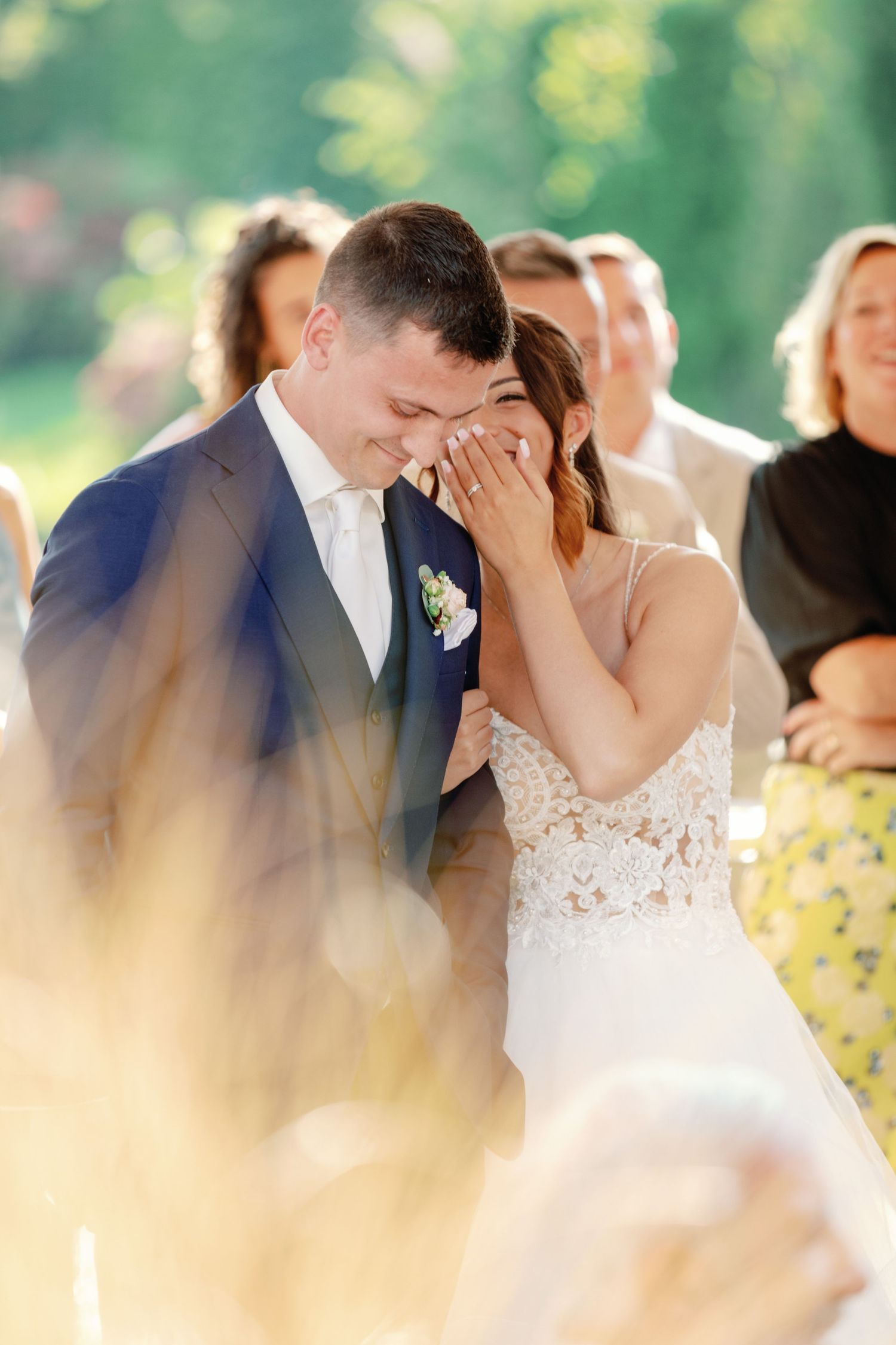 Romantic moment captured during outdoor wedding ceremony with soft bokeh effect.